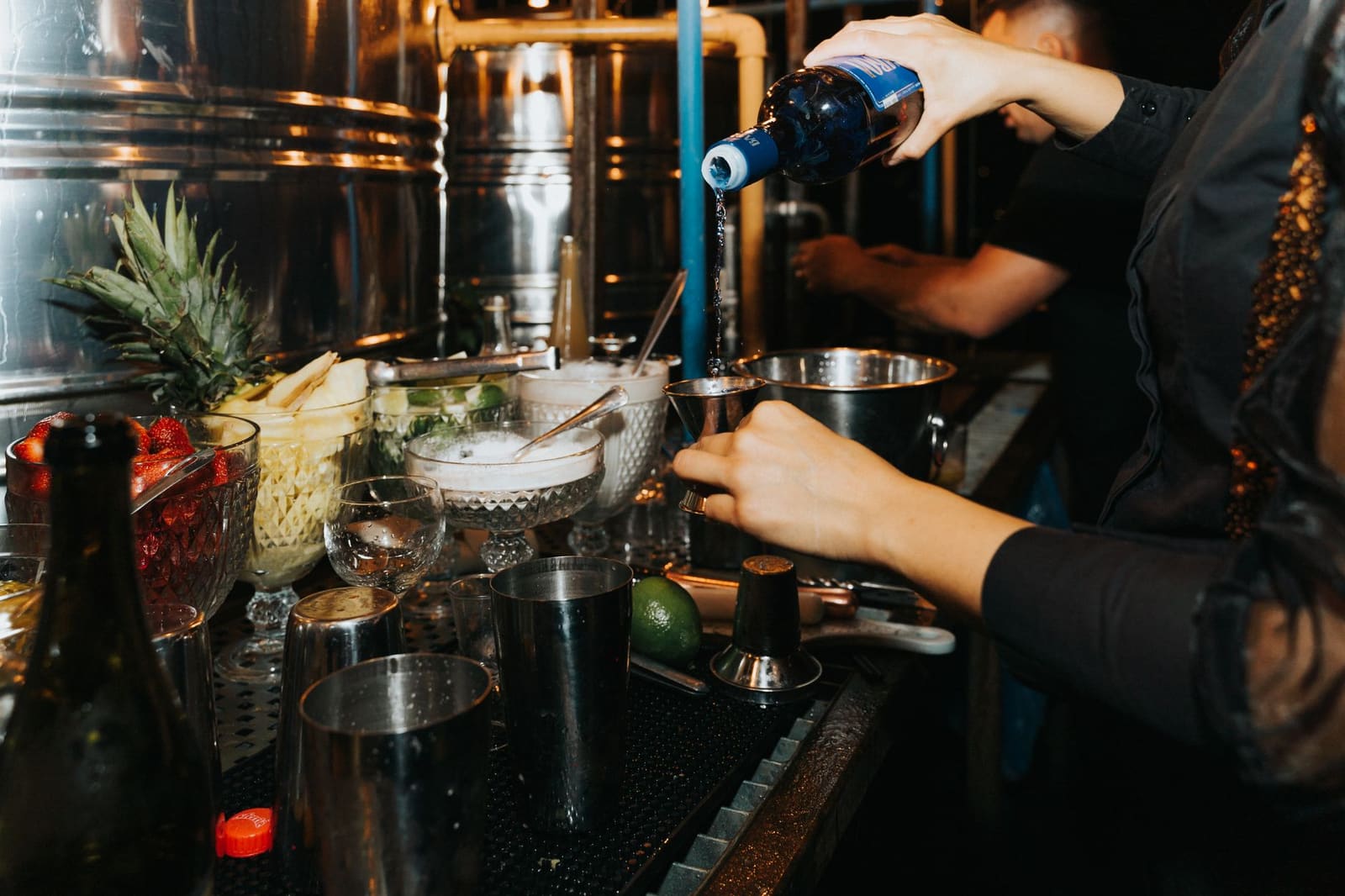 Bartender schenkt een cocktail achter de bar terwijl gasten hun bestelling doorgeven