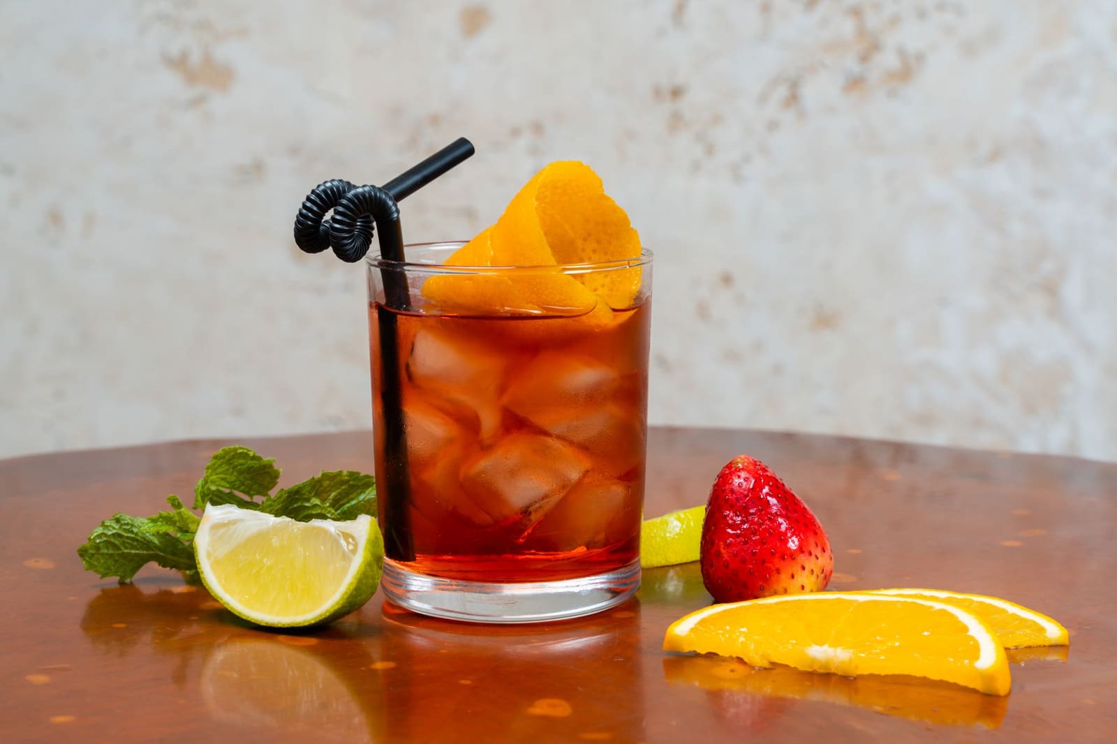Donkere rumcocktail geserveerd in een glas met ijsklontjes