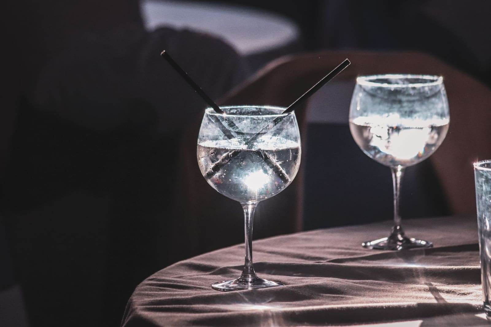 Proevers beoordelen glazen gin aan een tafel tijdens een blinde smaaktest