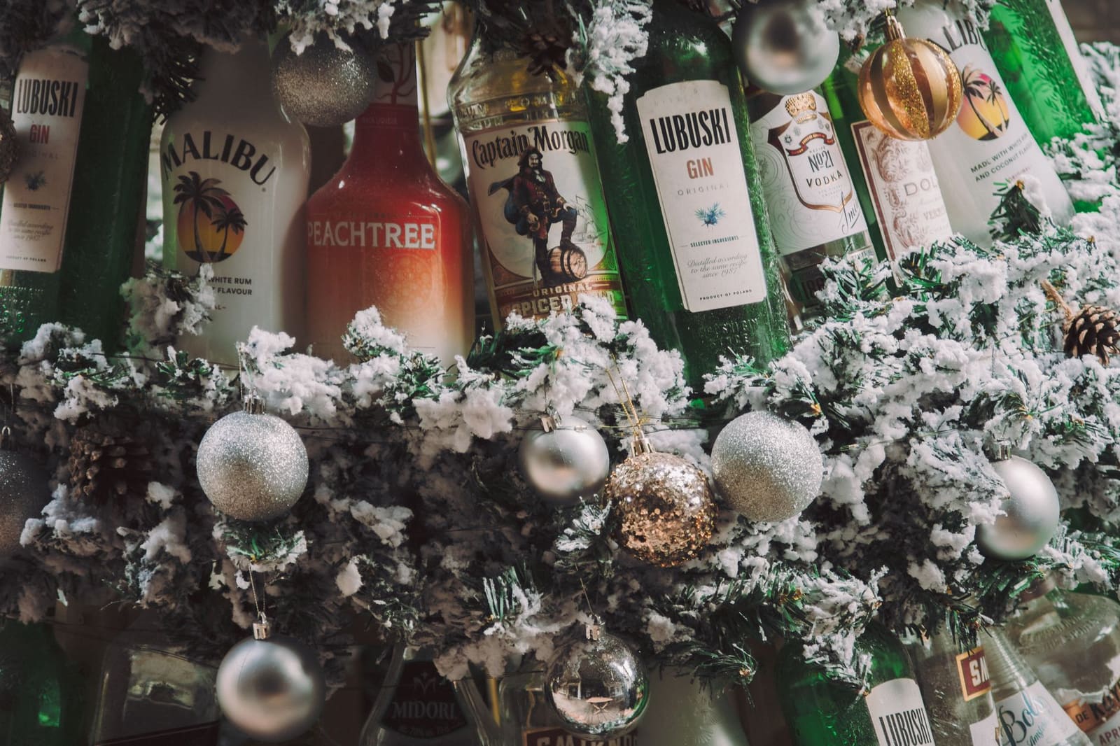Fles roze gin met bloemen en perziken op een tafel in een Engelse tuin