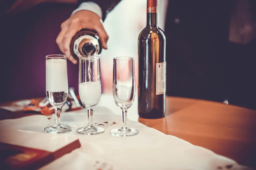 Mousserende wijn wordt ingeschonken in een glas met opstijgende bubbels