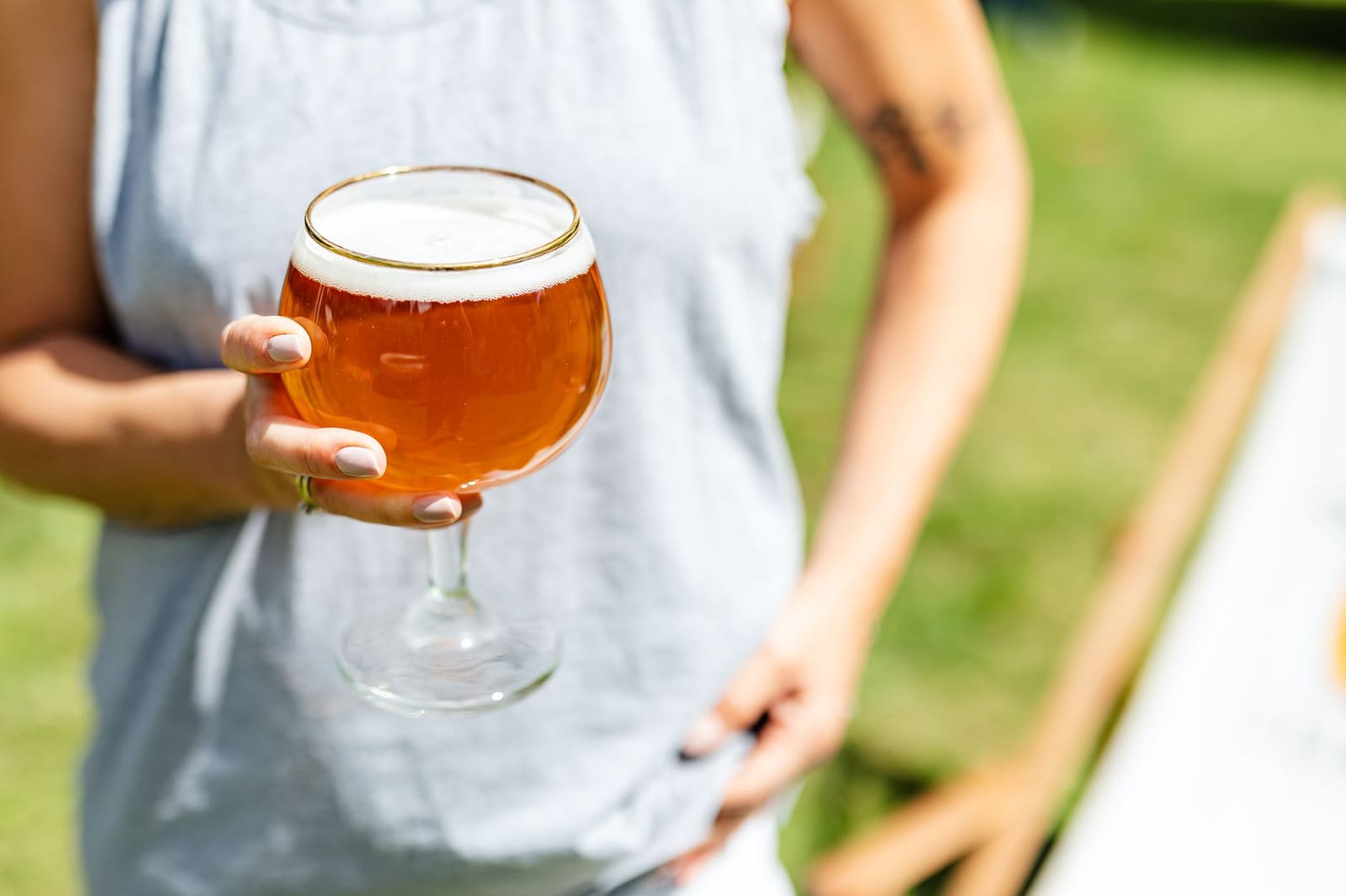 Vrouw met een glas drinkt op een zonnig terras in de stad