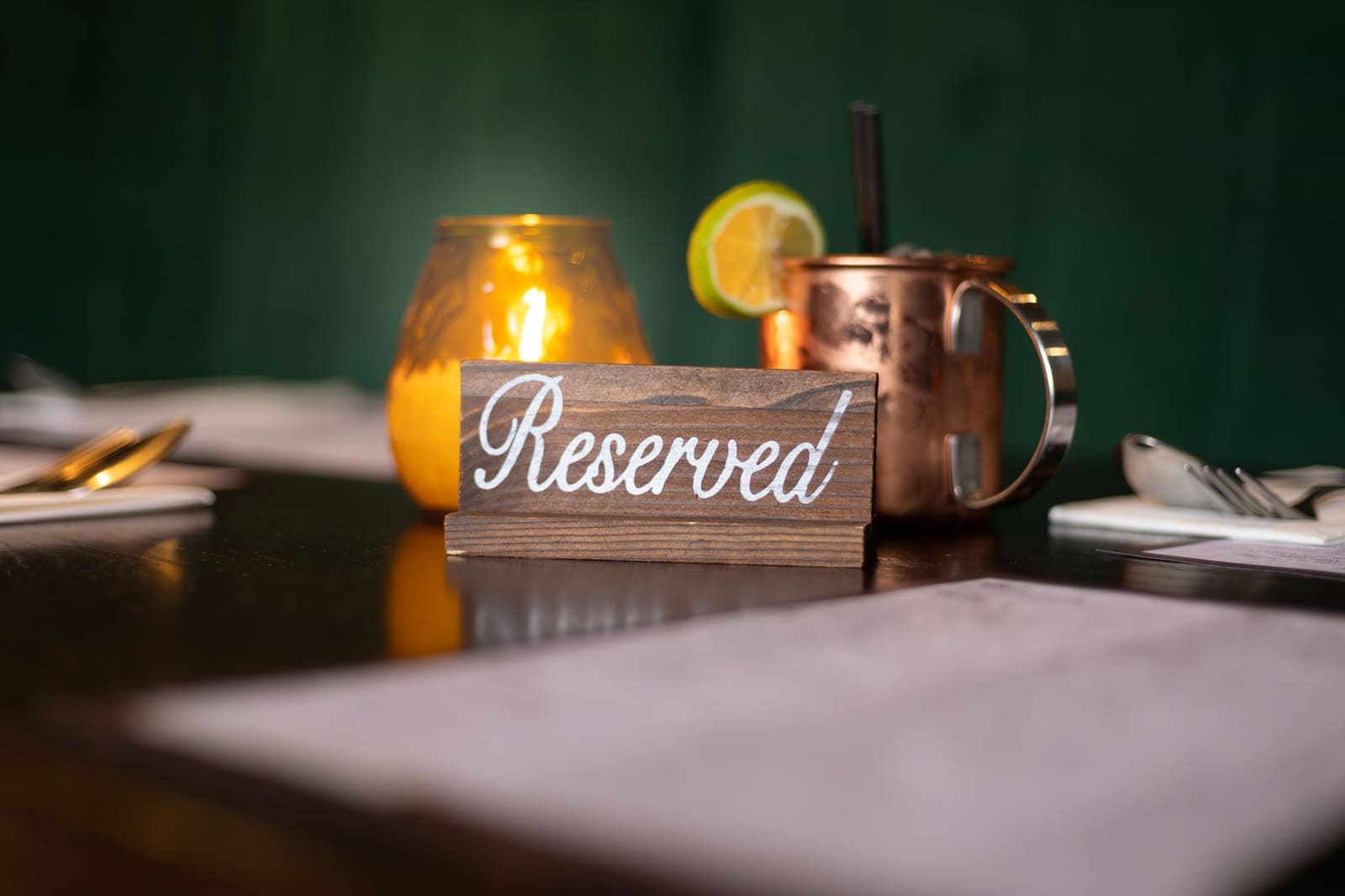 Gedekte restauranttafel met reserveringsbordje in een sfeervolle eetzaal