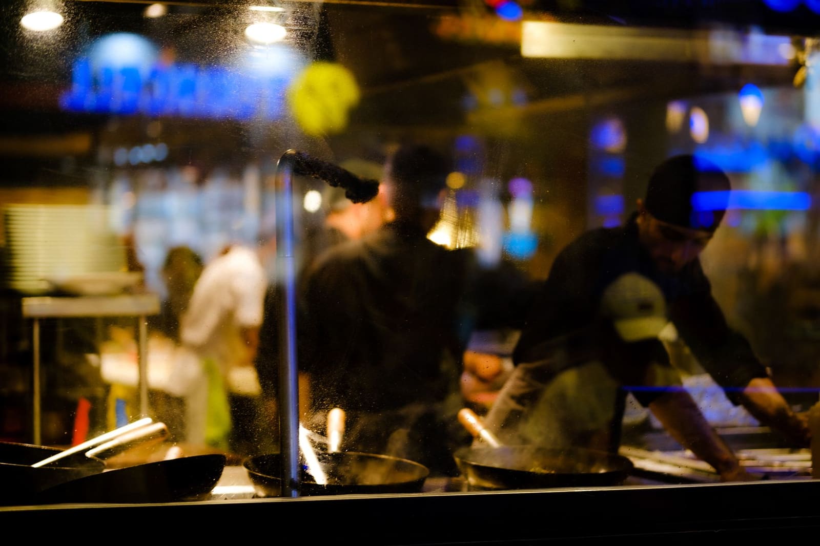 Een donkere restaurantkeuken met gedoofde fornuizen na sluitingstijd