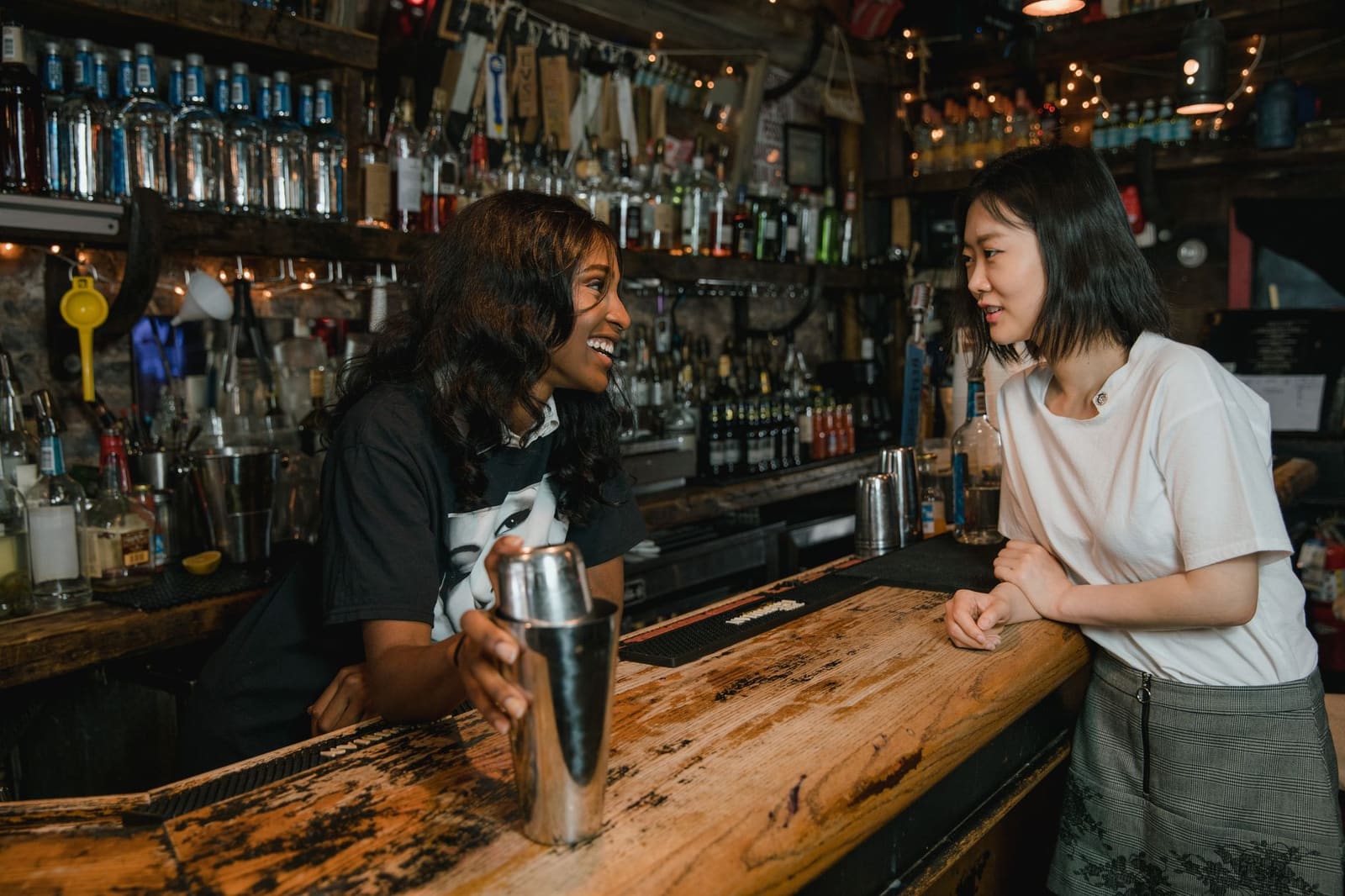 Vrouwelijke bartenders werken samen achter de bar tijdens een drukke avond in de horeca.