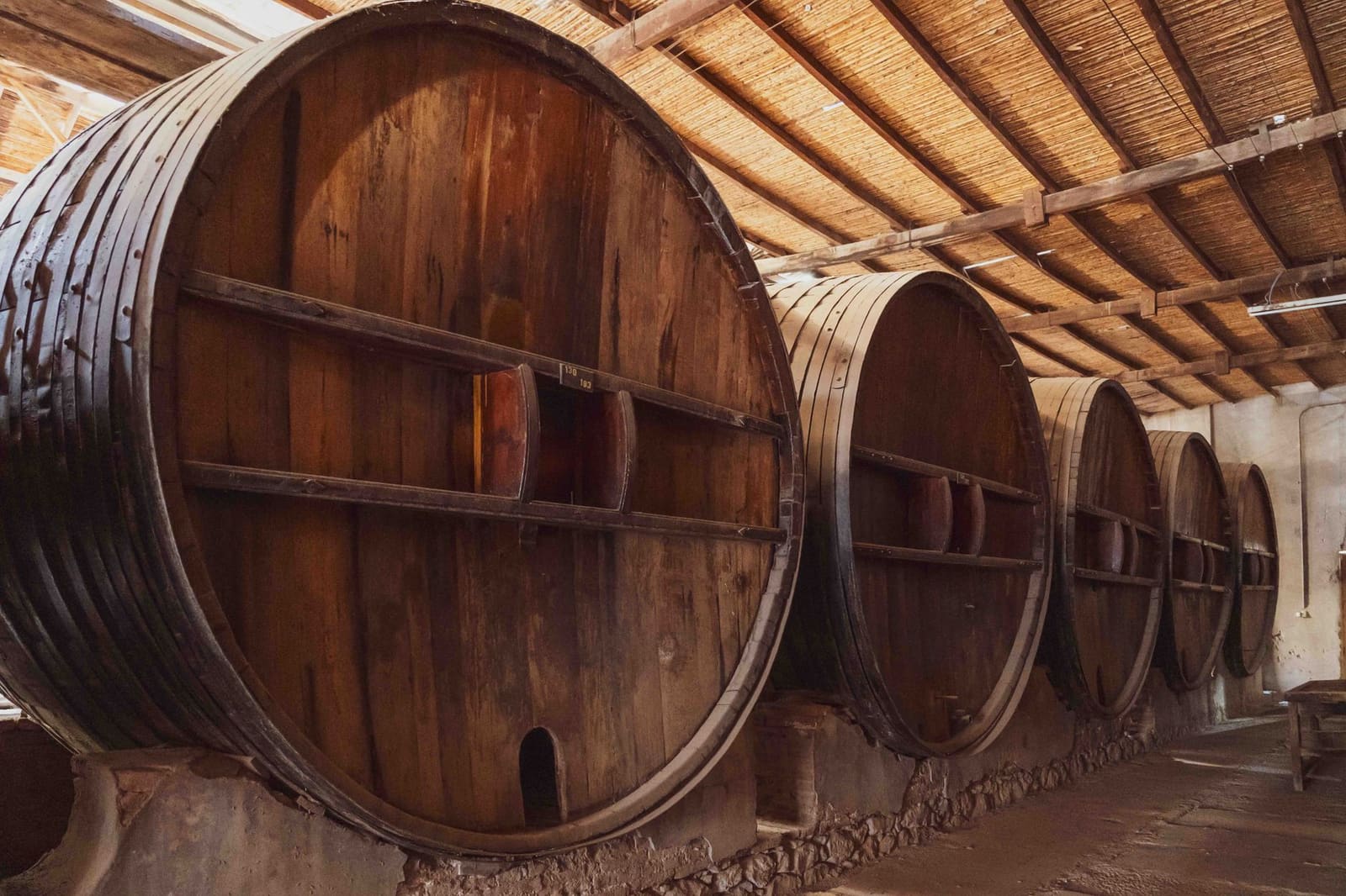 Rijen eikenhouten vaten met cognac in een traditionele kelder in Frankrijk