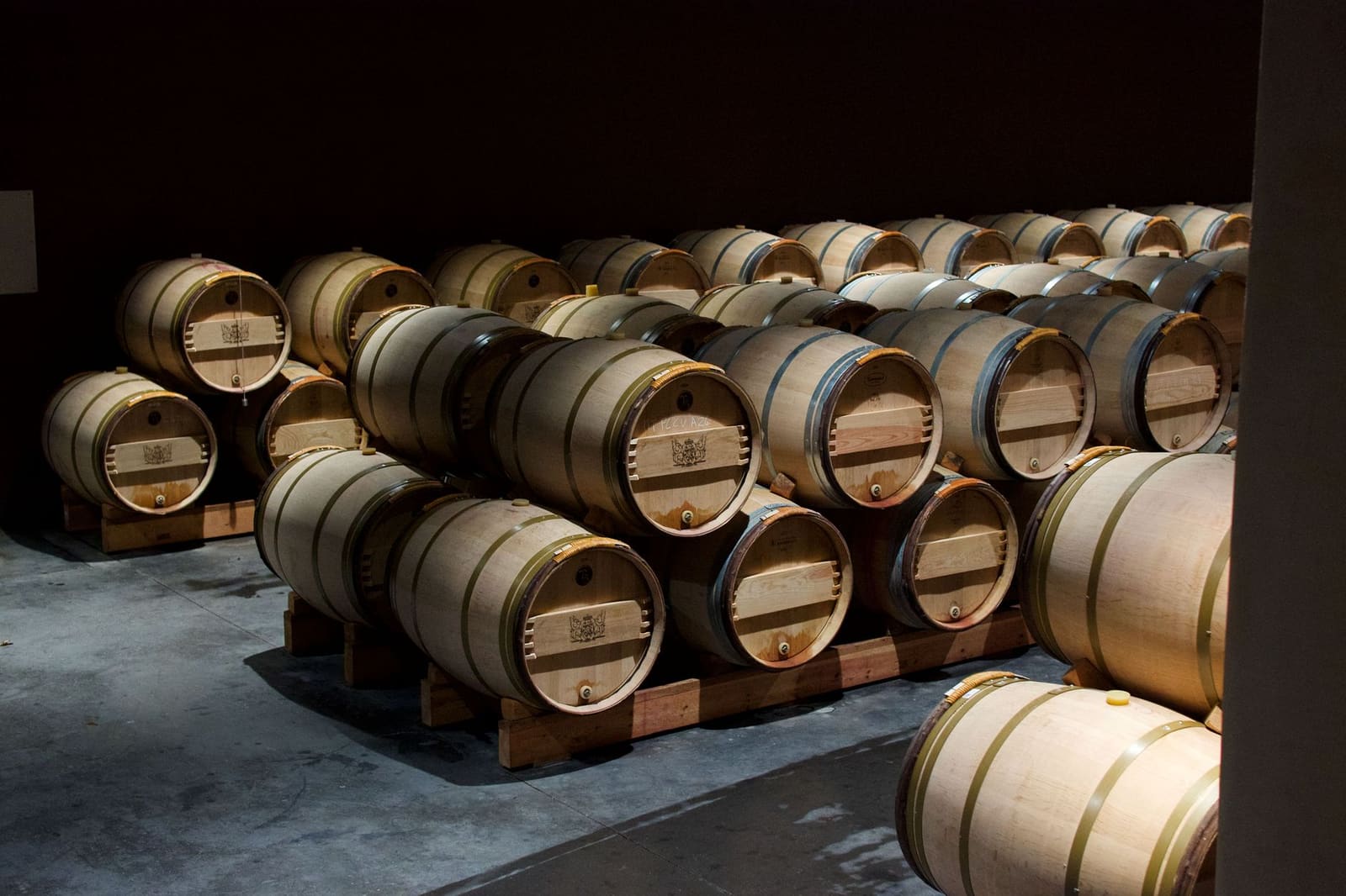 Eiken vaten waarin whisky rustig ligt te rijpen in een donkere kelder