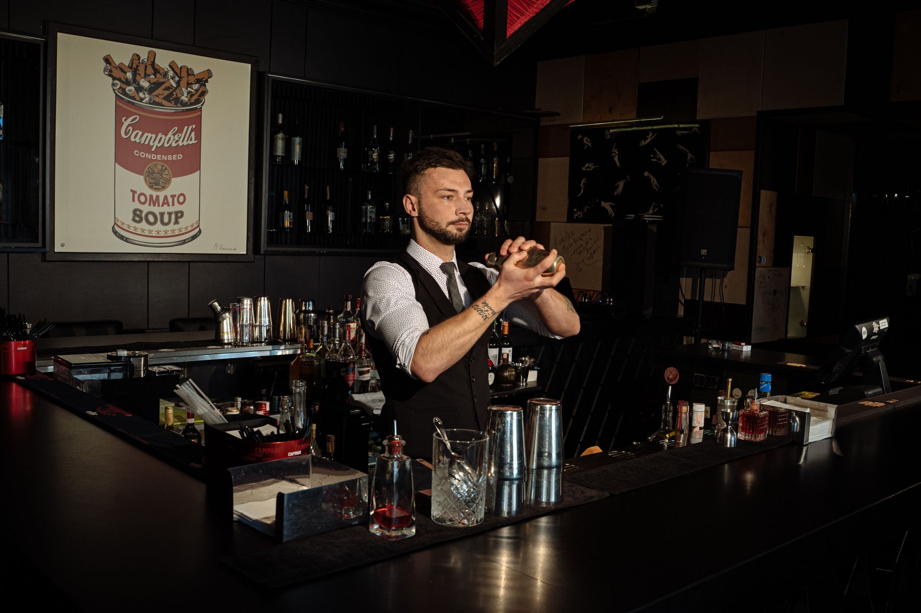 bartender maakt een cocktail achter een kleine, intieme bar zonder zichtbare menukaart
