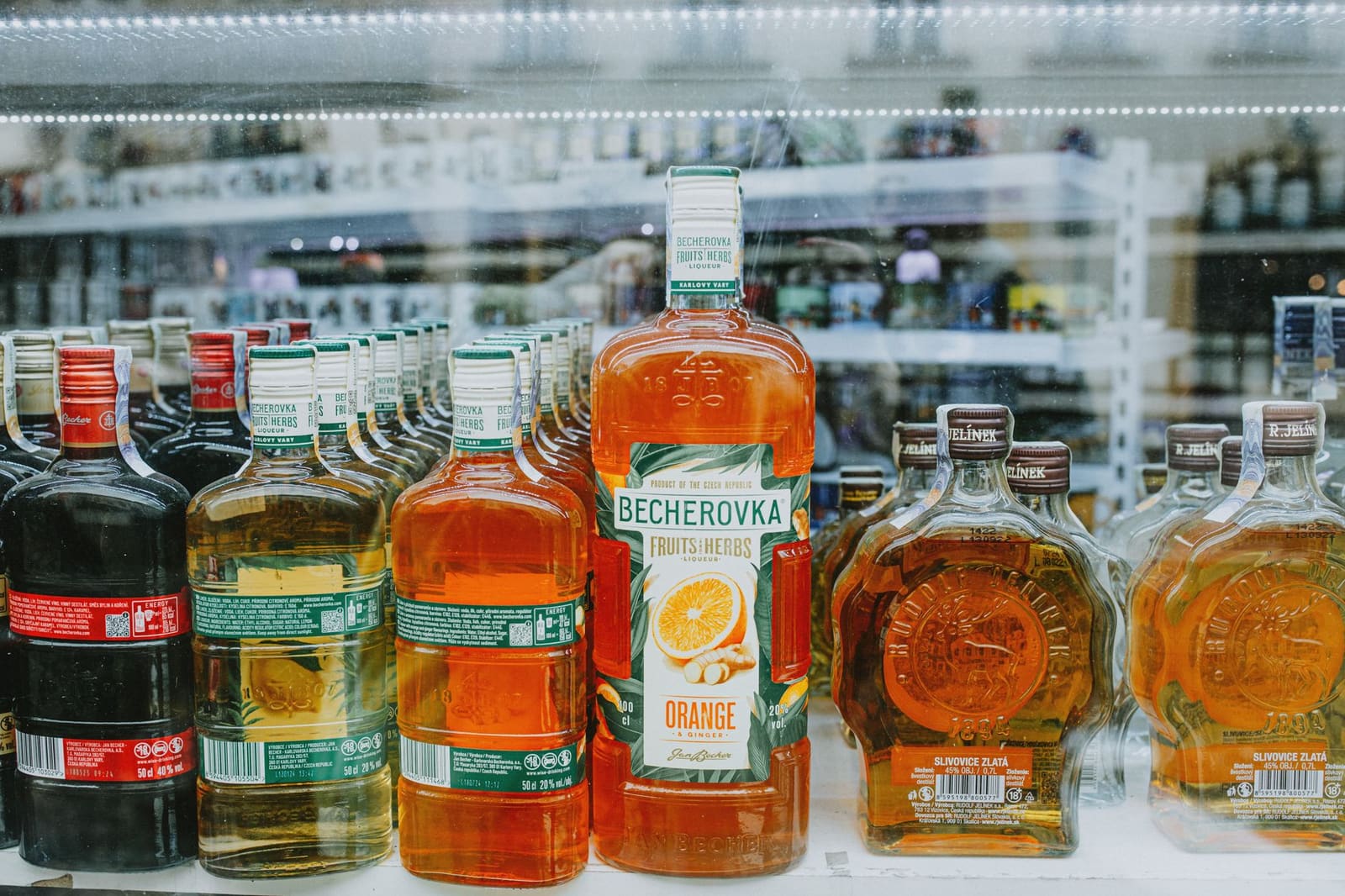 Rij flessen kruidenlikeur op een plank achter de bar