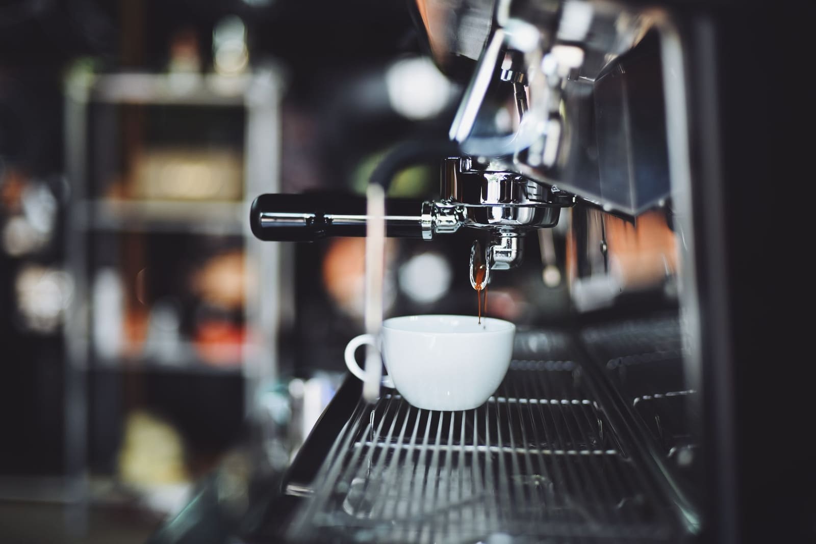 Espressomachine die een kopje sterke koffie tapt met een gouden crème