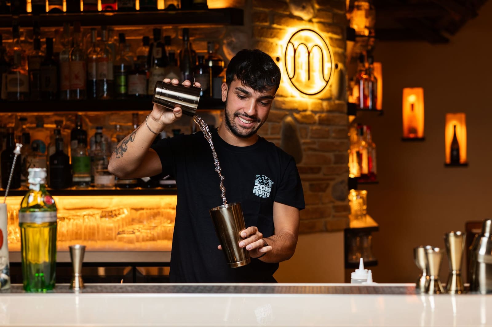 Bartender schudt een cocktail in een shaker achter de bar