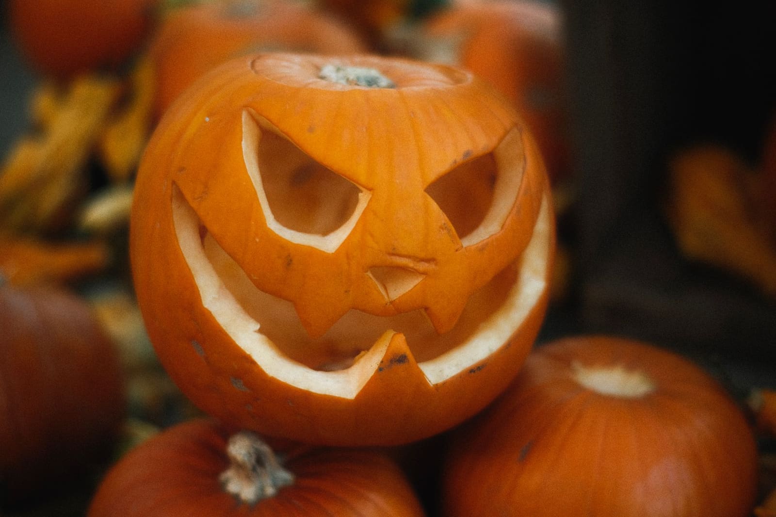Uitgesneden pompoen met griezelig gezicht die het Halloween-thema benadrukt op de bar