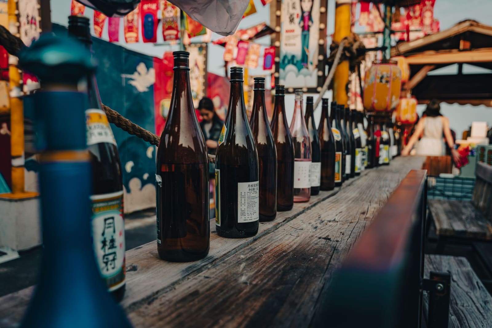 Flessen sake netjes opgesteld op een plank in een bar