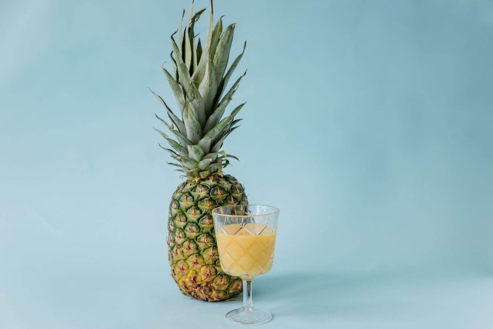 Piña colada in een hoog glas met ananas en een parasolletje.
