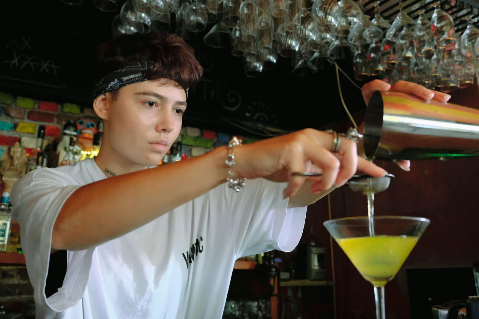 Bartender schudt een roze cocktail met een shaker achter de bar