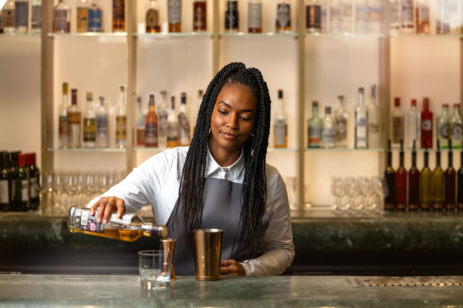 Bartender achter de bar tijdens een drukke dienst, symbool voor de horecamedewerkers die Hospitality Action steunt