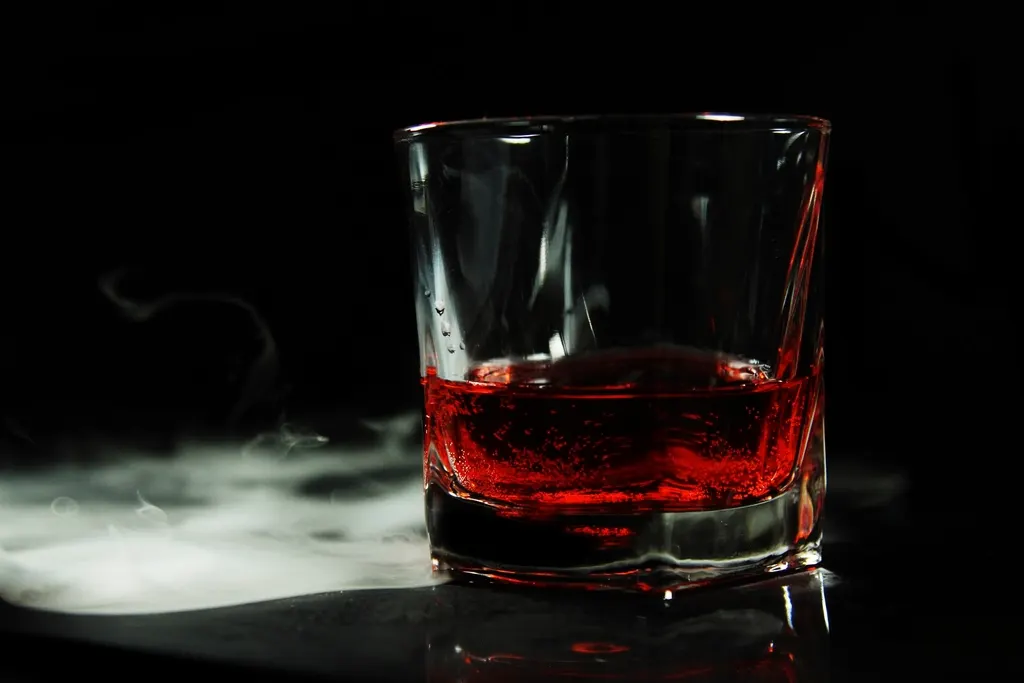 Glas whiskey puur geschonken zonder ijs op een houten bar
