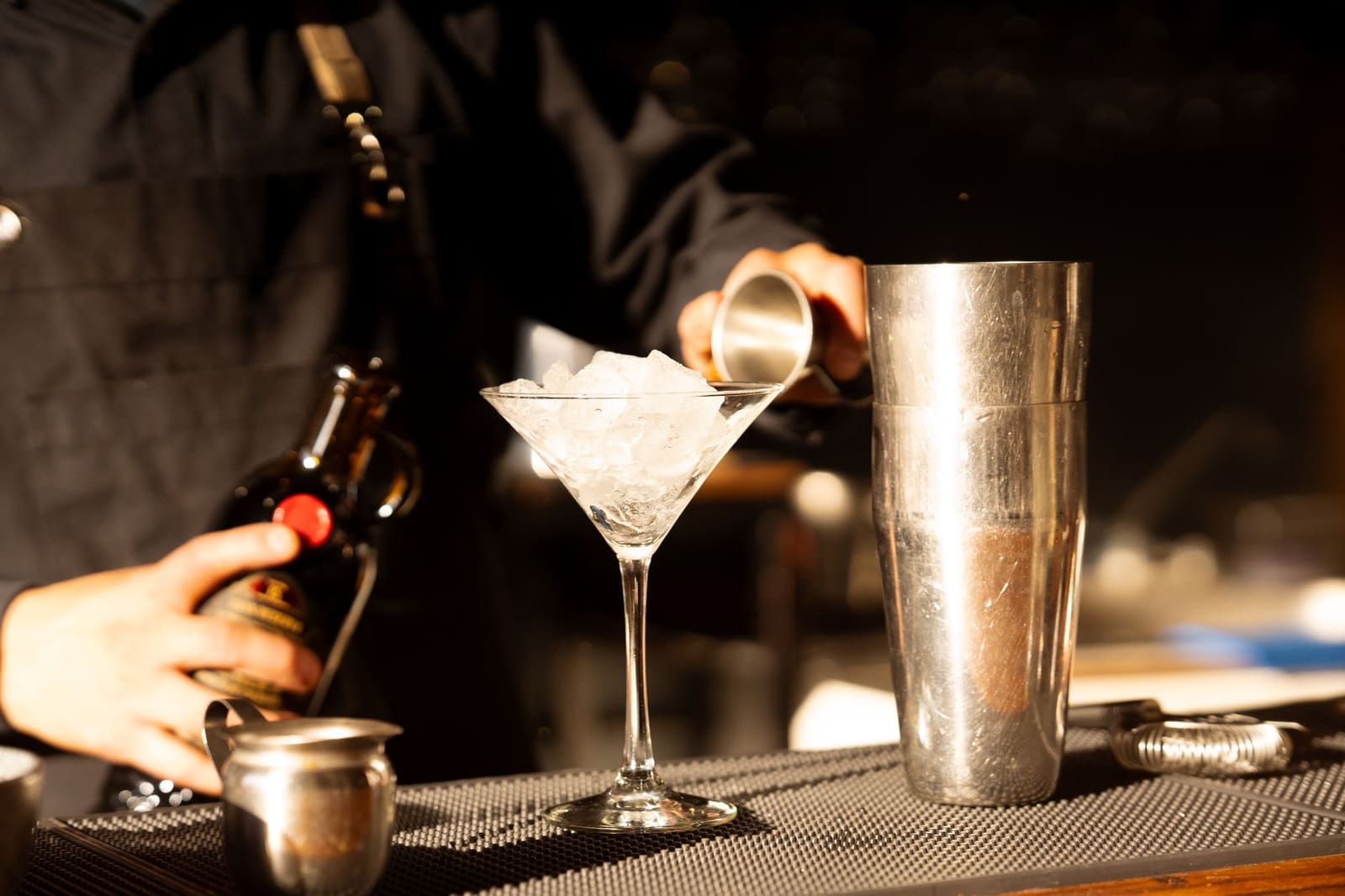 Bartender die een whiskeycocktail inschenkt tijdens een internationale bartenderwedstrijd