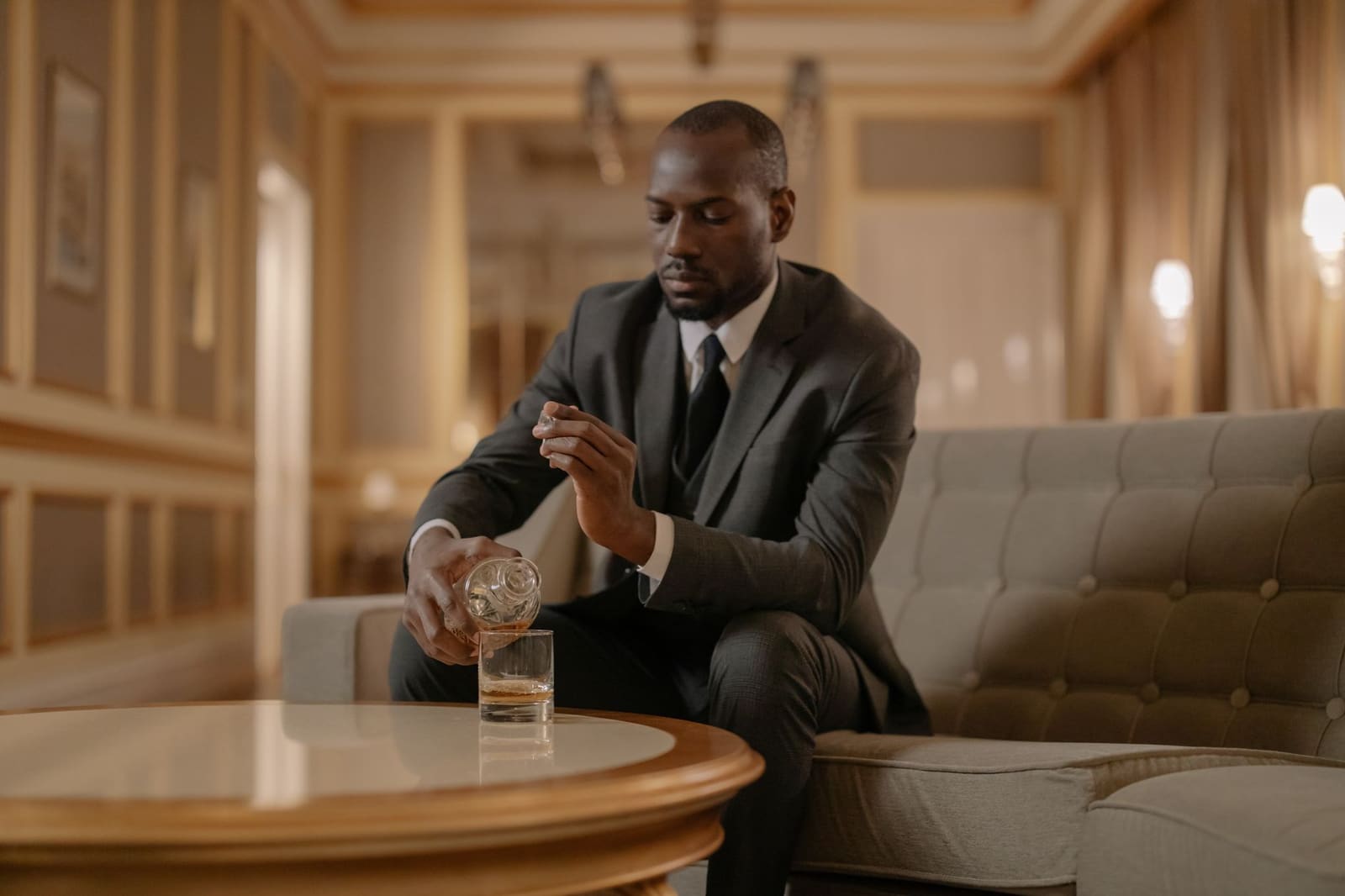 Ierse whiskey wordt uitgeschonken in een tumblerglas met een ijsblokje