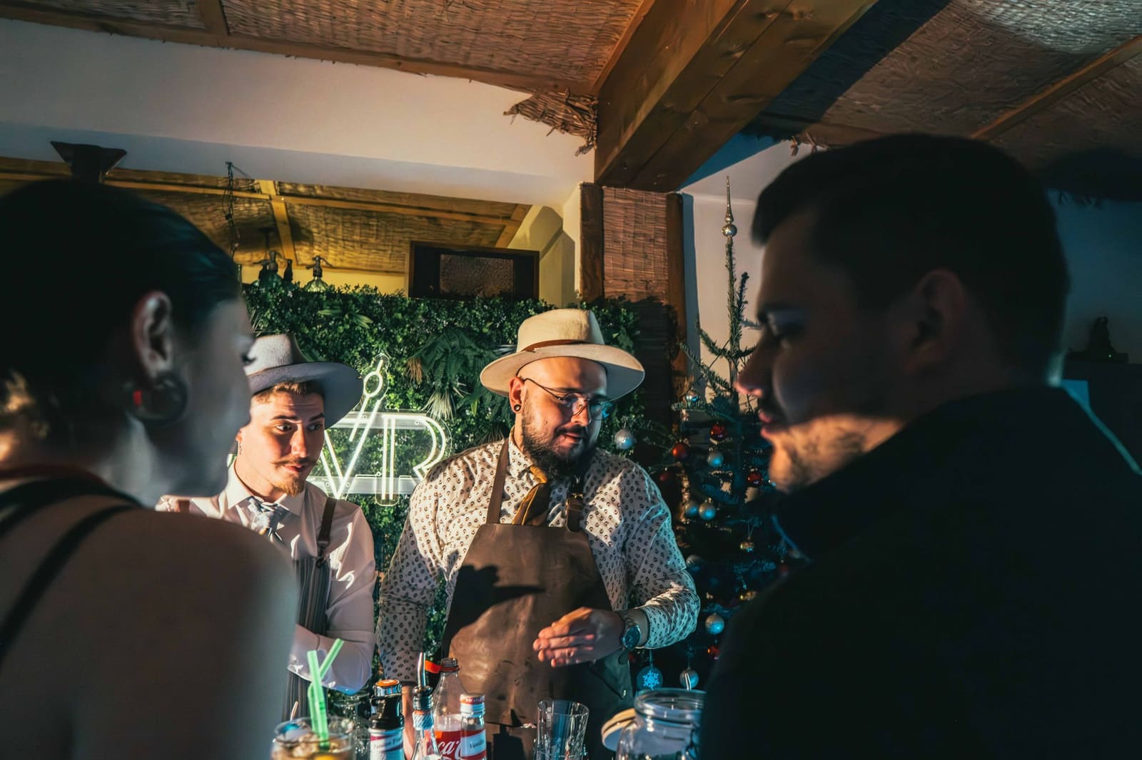 Bartender schenkt drankjes in aan gasten in een feestelijk verlichte bar