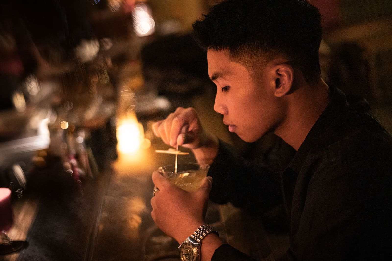 Bartender roert een Negroni met ijs achter de bar tijdens Negroni Week