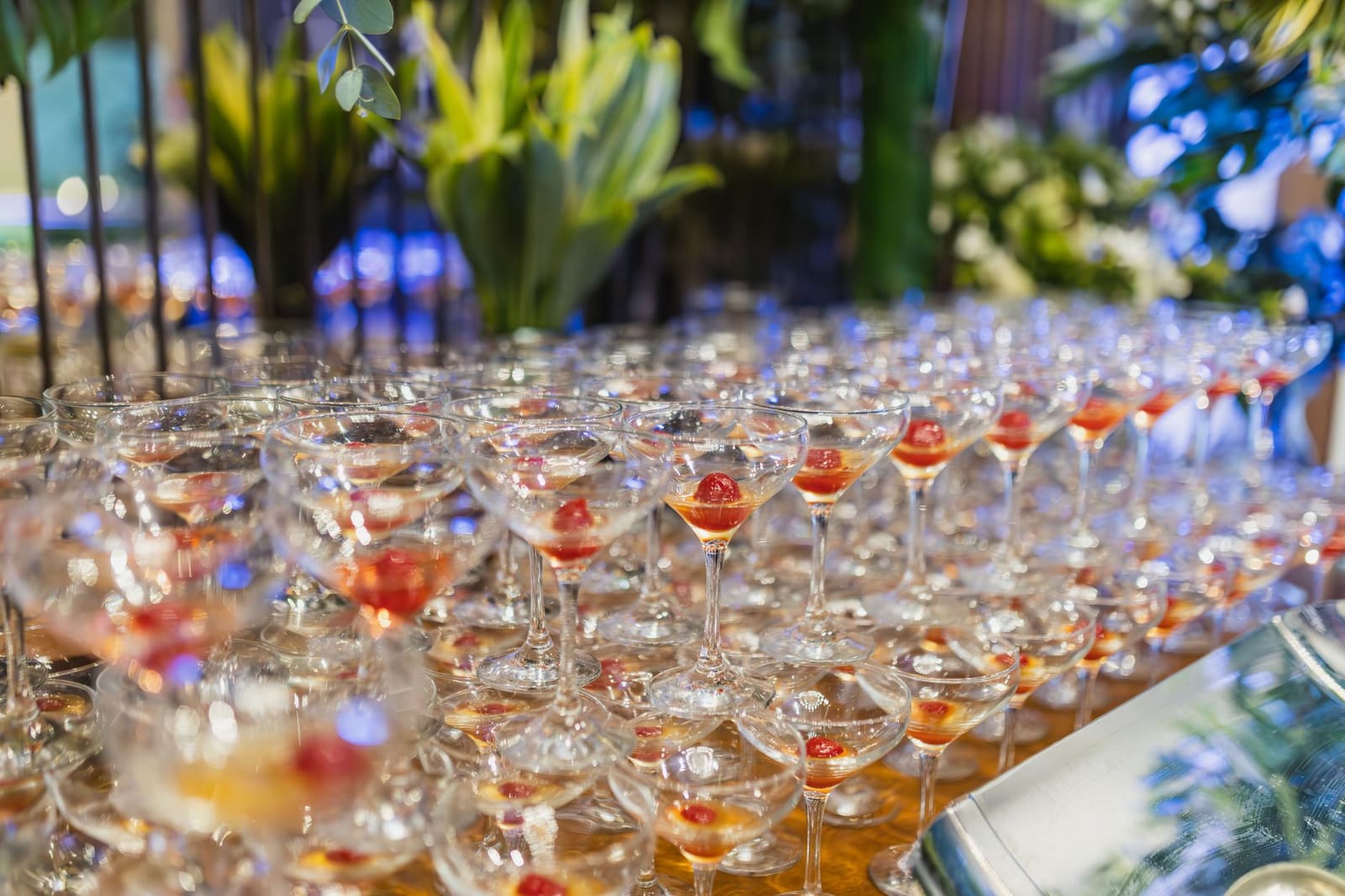 Rij gekleurde cocktails met garnering op een bar