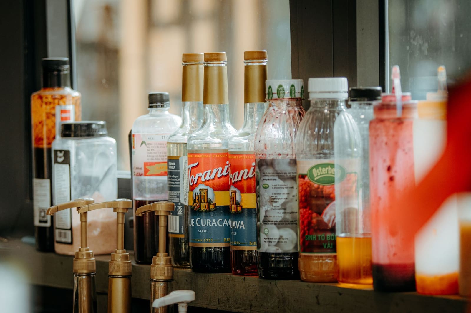 Rij gekleurde siroopflessen gebruikt voor het bereiden van cocktails