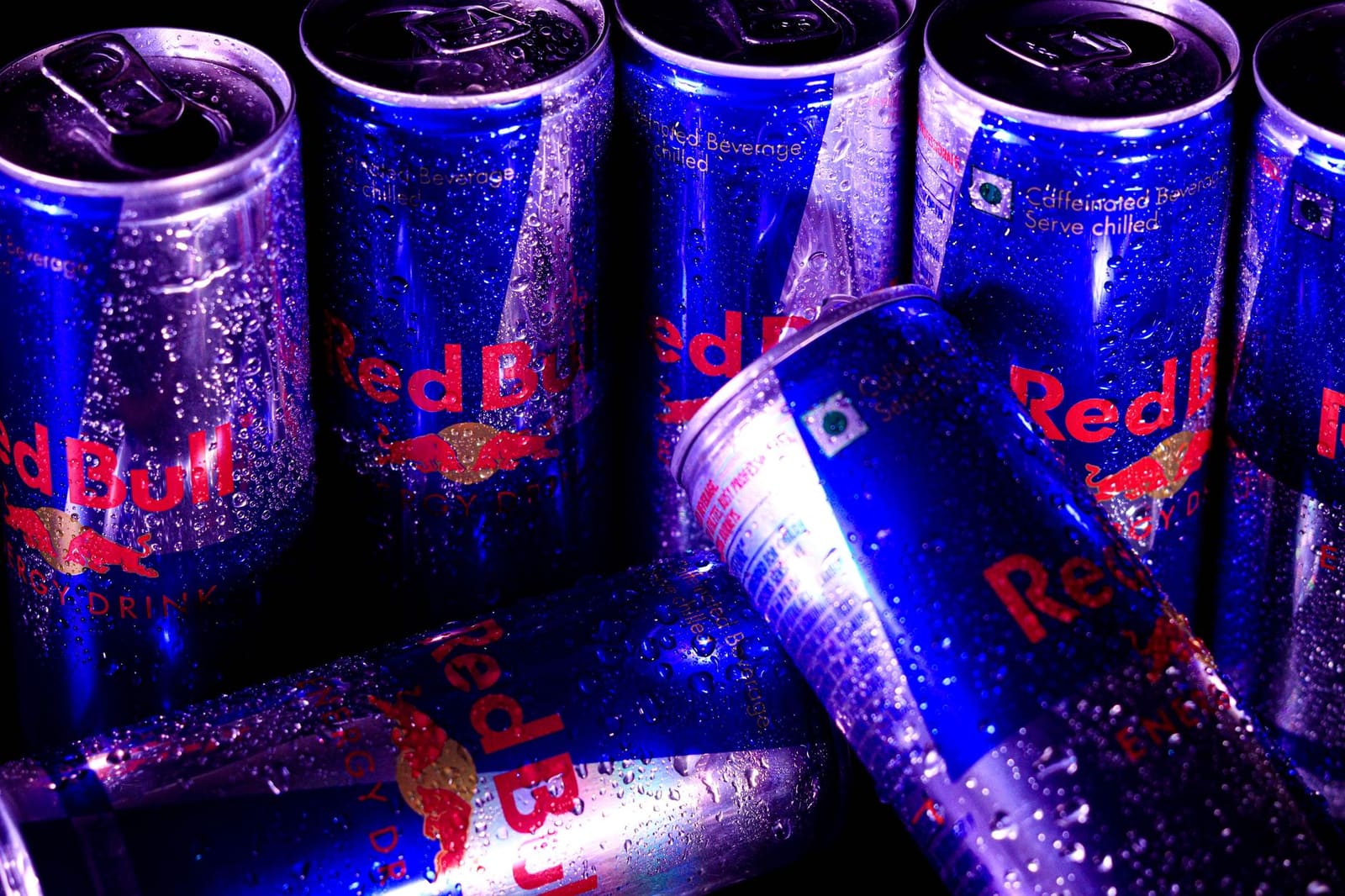 Blikjes energiedrank naast elkaar opgesteld in een koeling of schap