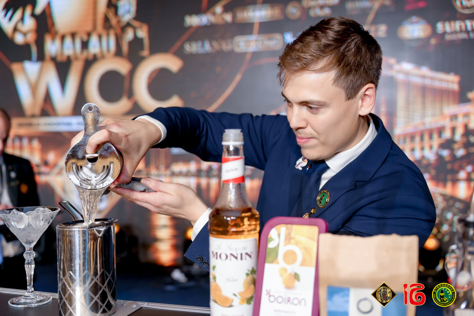 Bartender schenkt een cocktail in voor de WCC-wand tijdens het IBA World Cocktail Championship 2026 in Macau