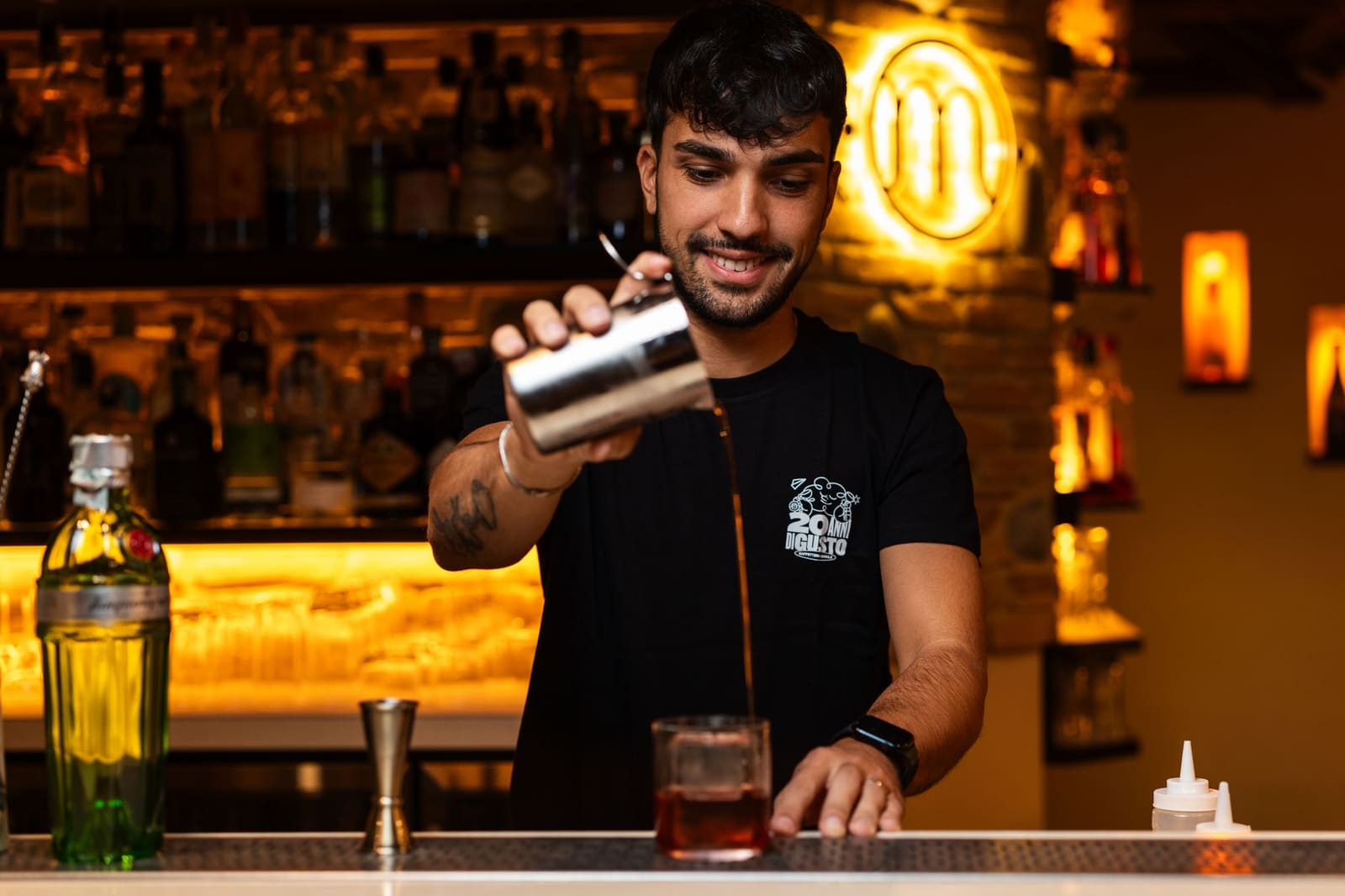 Bartender mengt een cocktail met Campari achter de bar