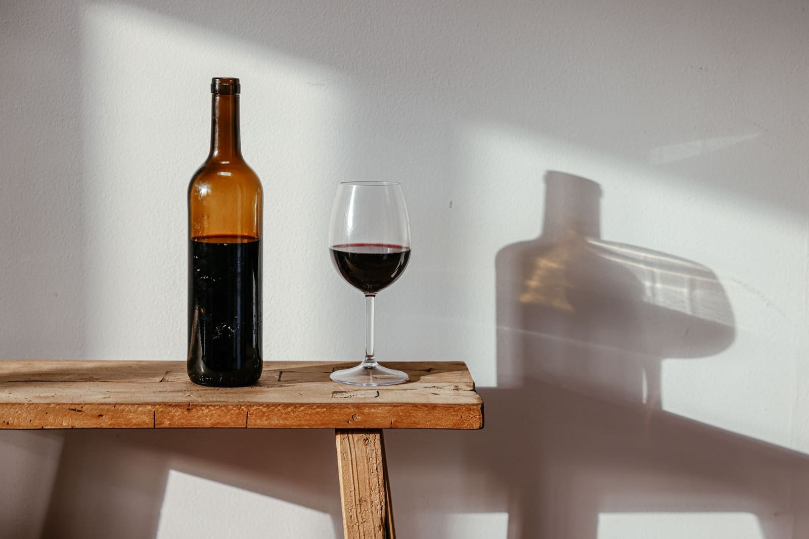 Glas en fles rode wijn op tafel