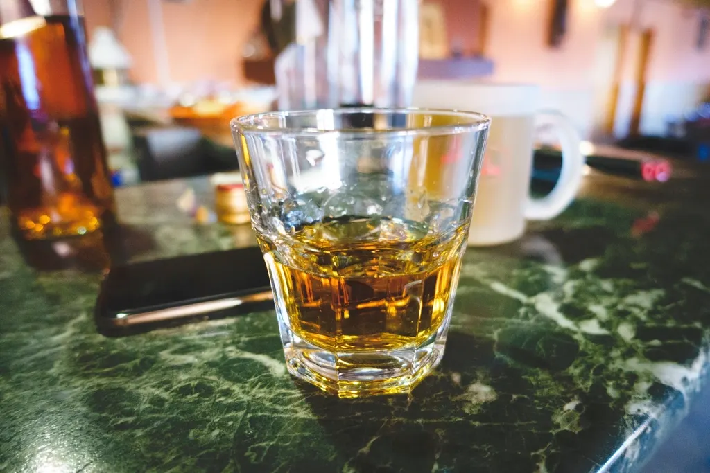Glas whisky op een houten bar