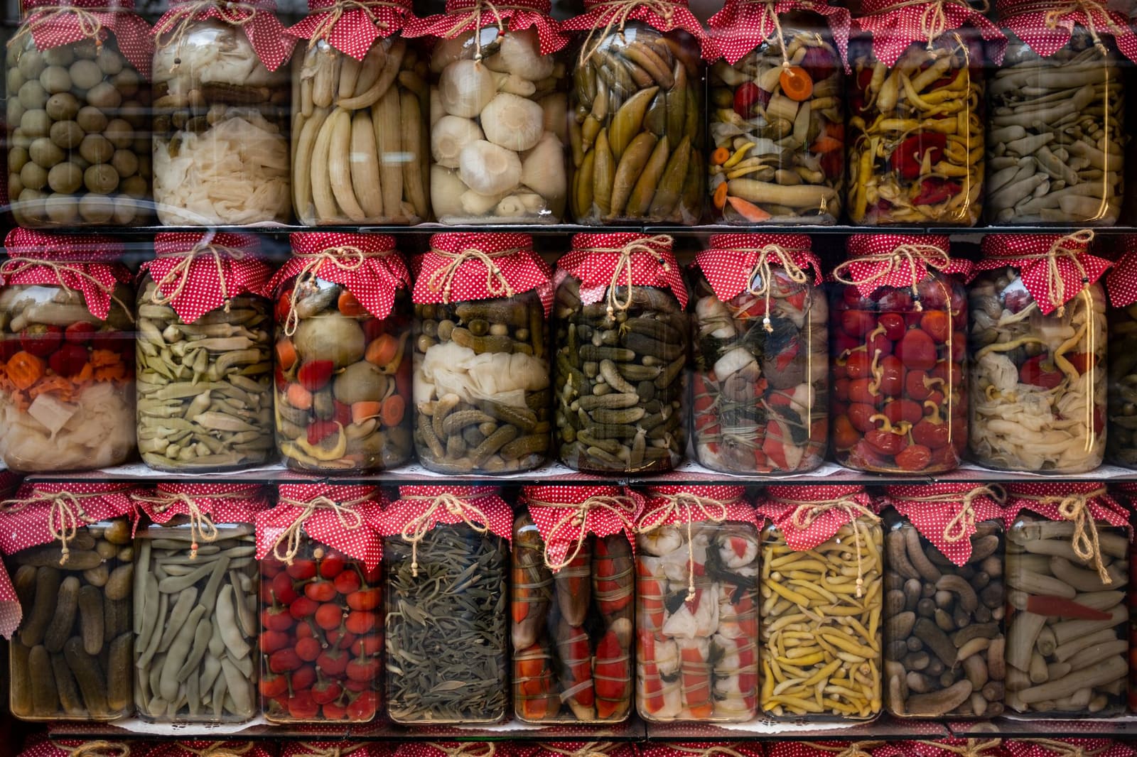 Glazen pot met ingelegde groenten zoals wortels, uien en pepers