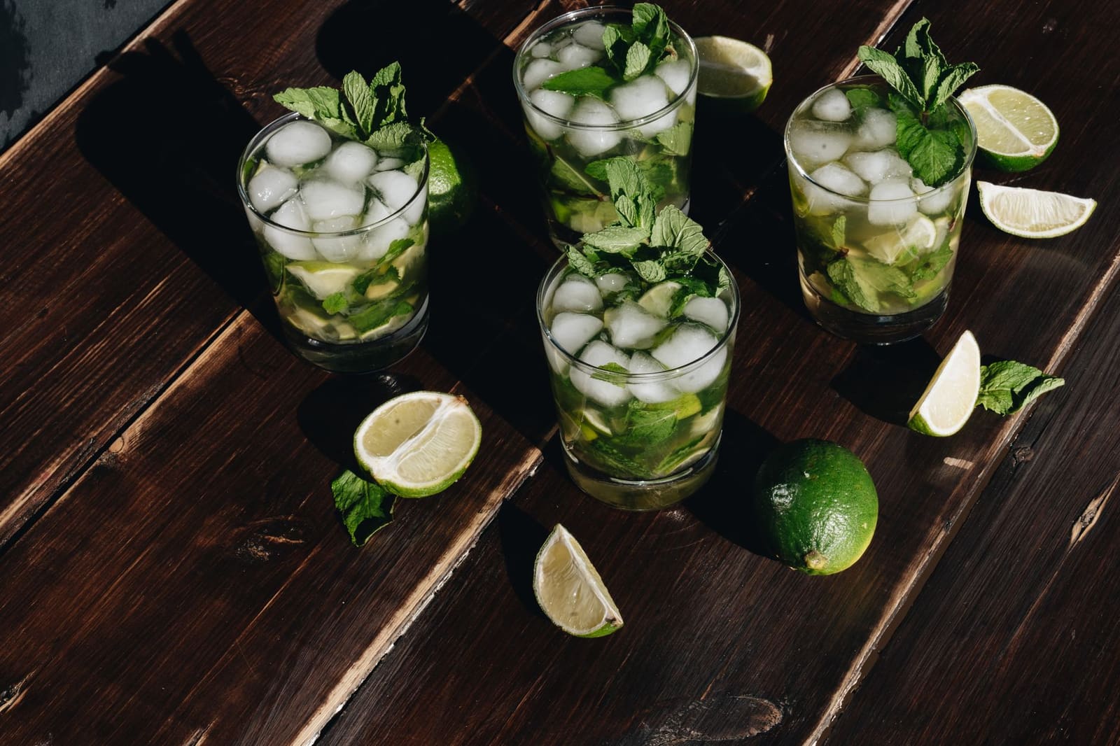 Verse Mojito met munt, limoen en ijs in een hoog glas op een bartafel
