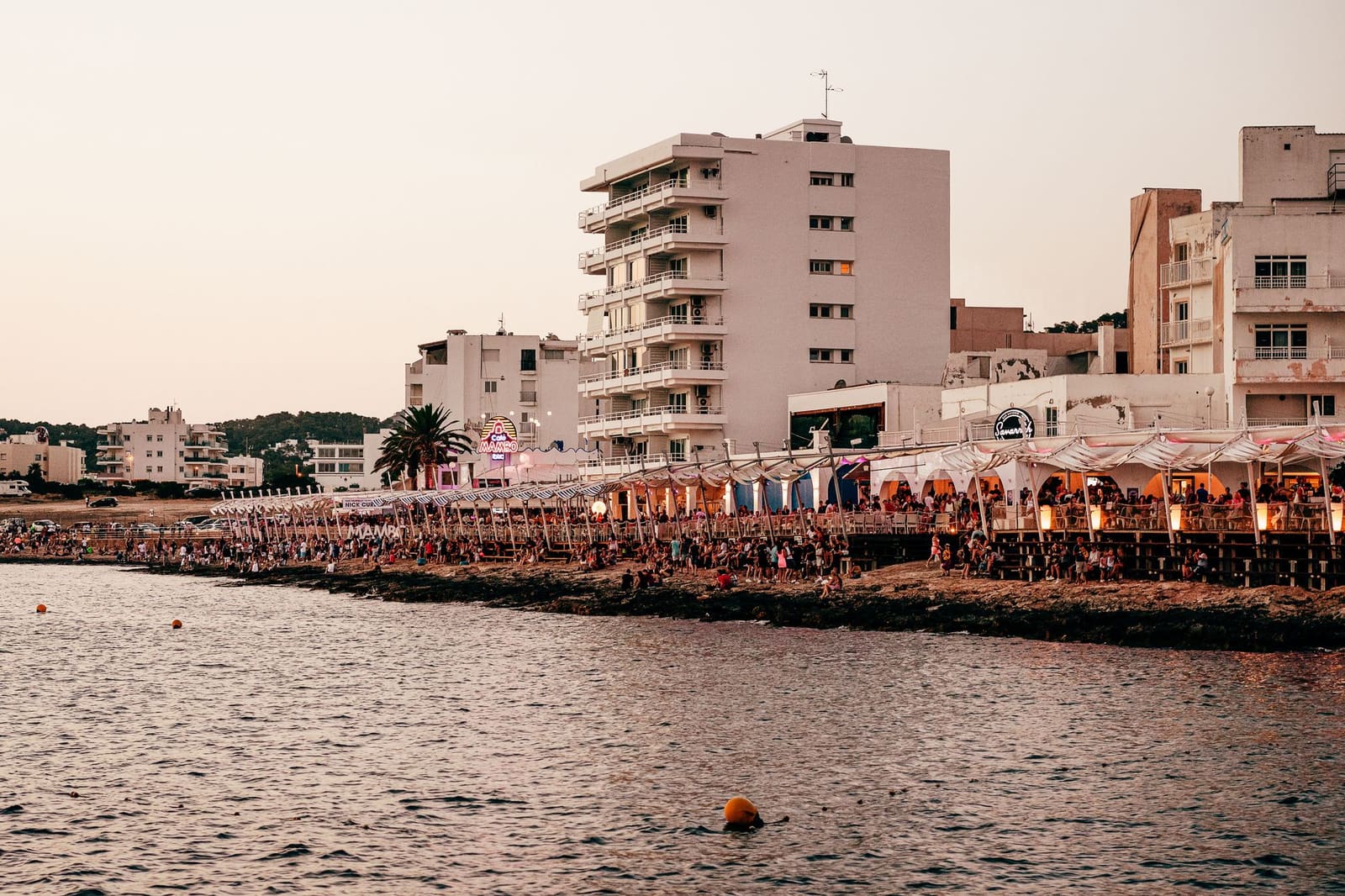 Zomerse strandbar op Ibiza met lounge stoelen en zachte zonsondergang