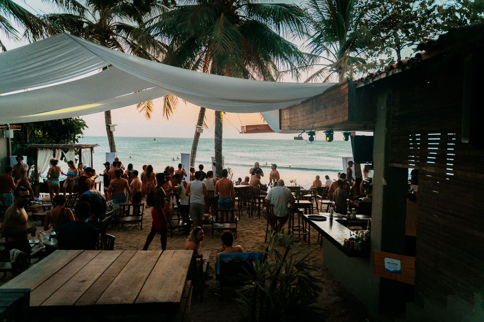Mensen dansen buiten bij een strandbar met verlichting in de avond