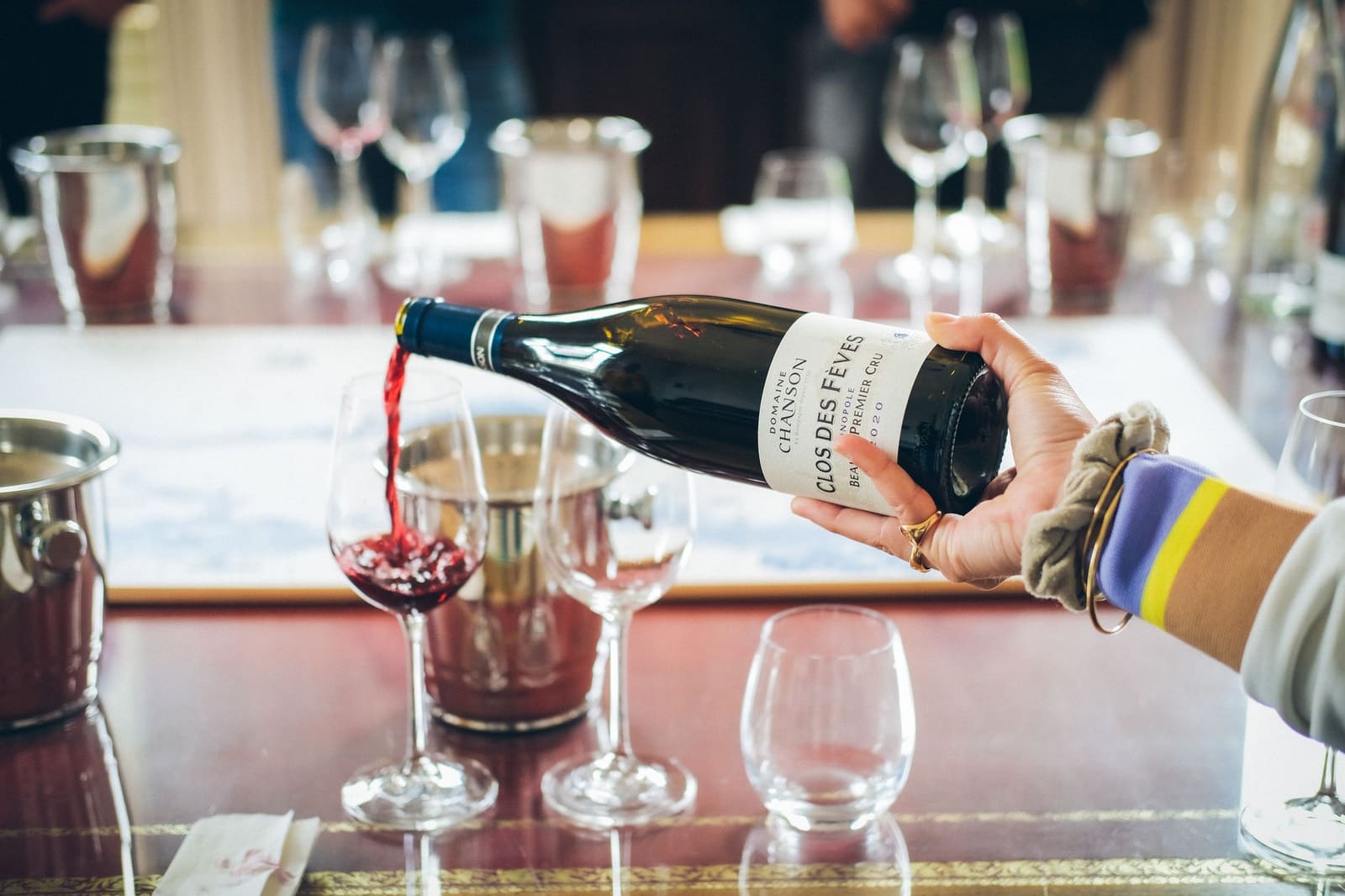 Een fles rode wijn wordt ingeschonken in een glas tijdens een proeverij