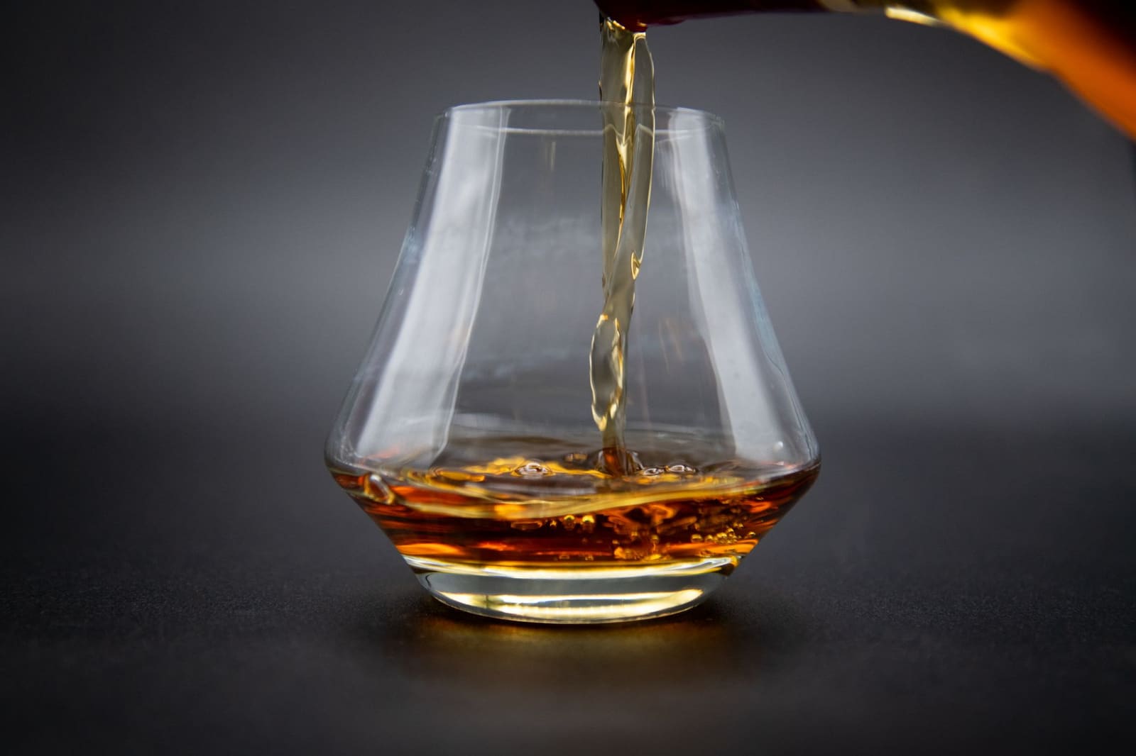 Glas bourbon puur geschonken, met amberkleurige whiskey in het licht