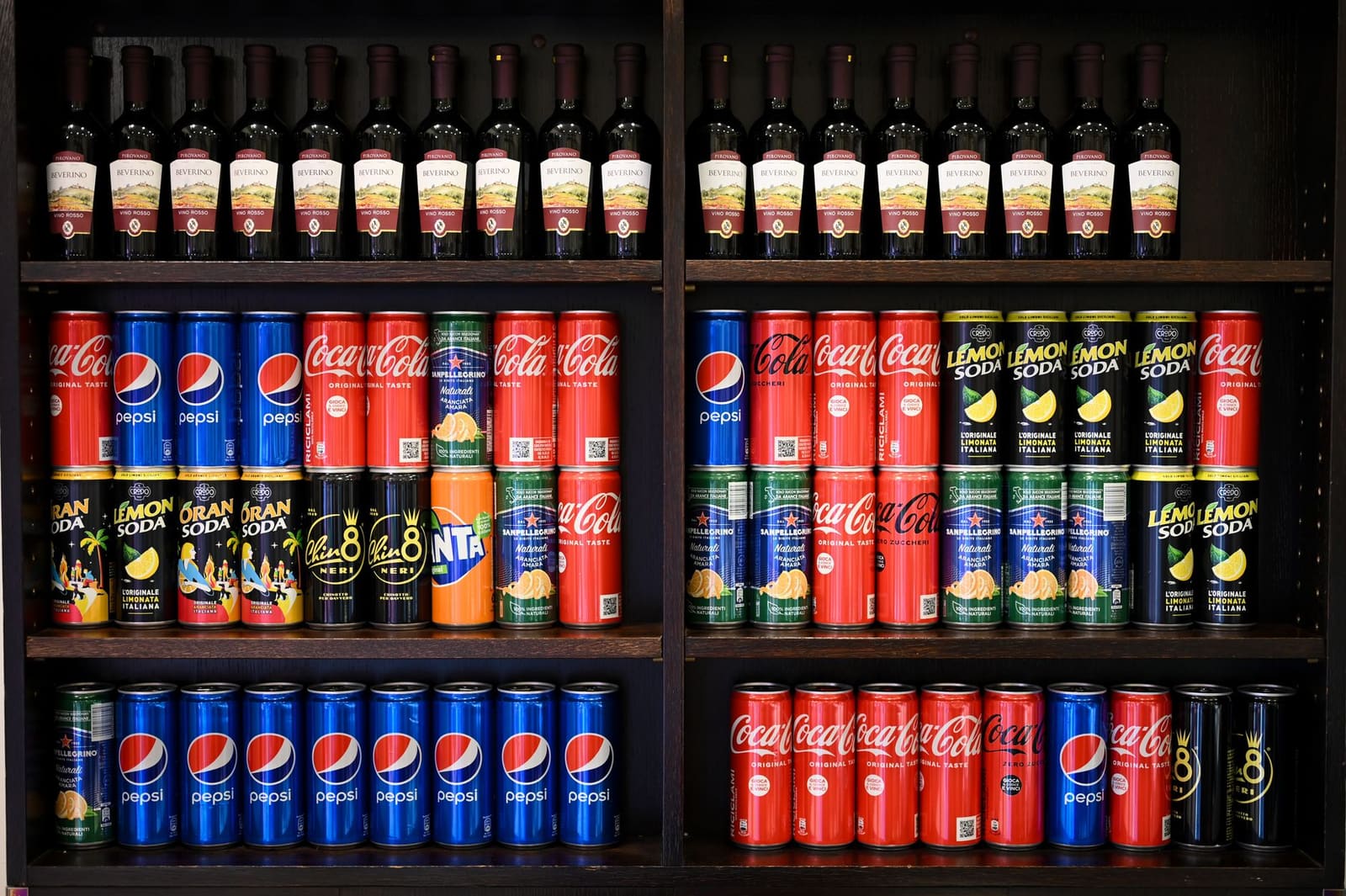 Flessen cola en frisdrank op een plank achter de bar, gebruikt als mixer voor cocktails