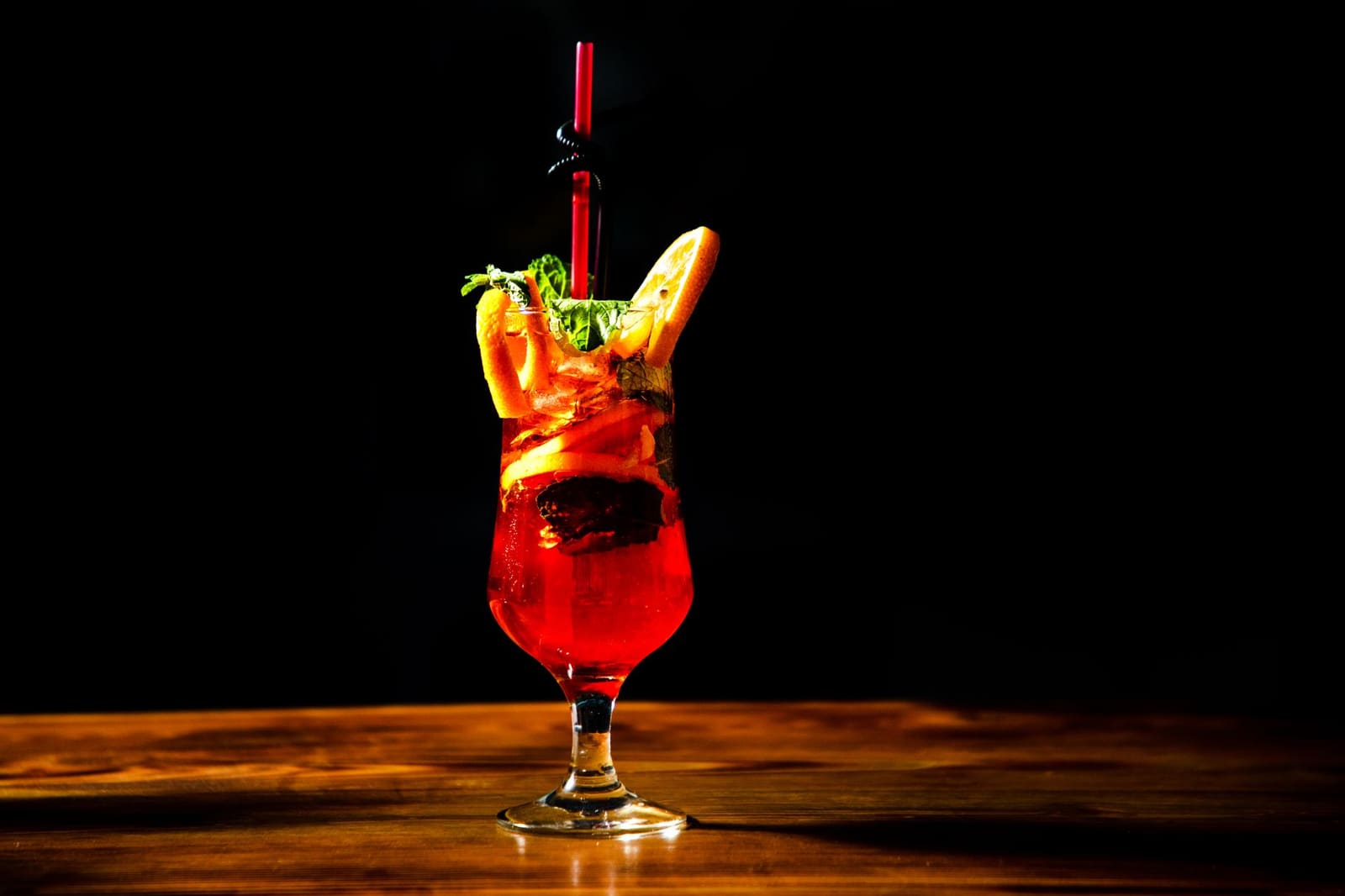 Glas met rum cocktail en ijsblokjes op een houten bar