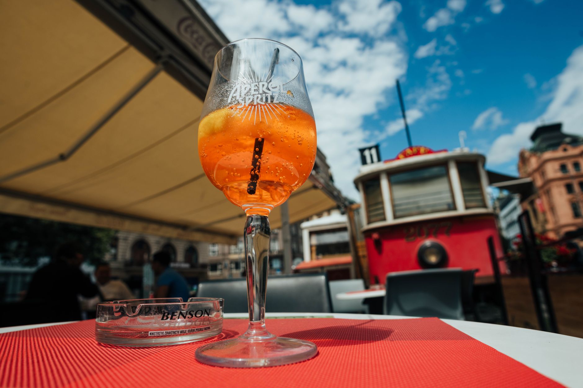 Glas alcoholvrije Aperol Spritz met ijs en sinaasappelschijf op een zonnig terras
