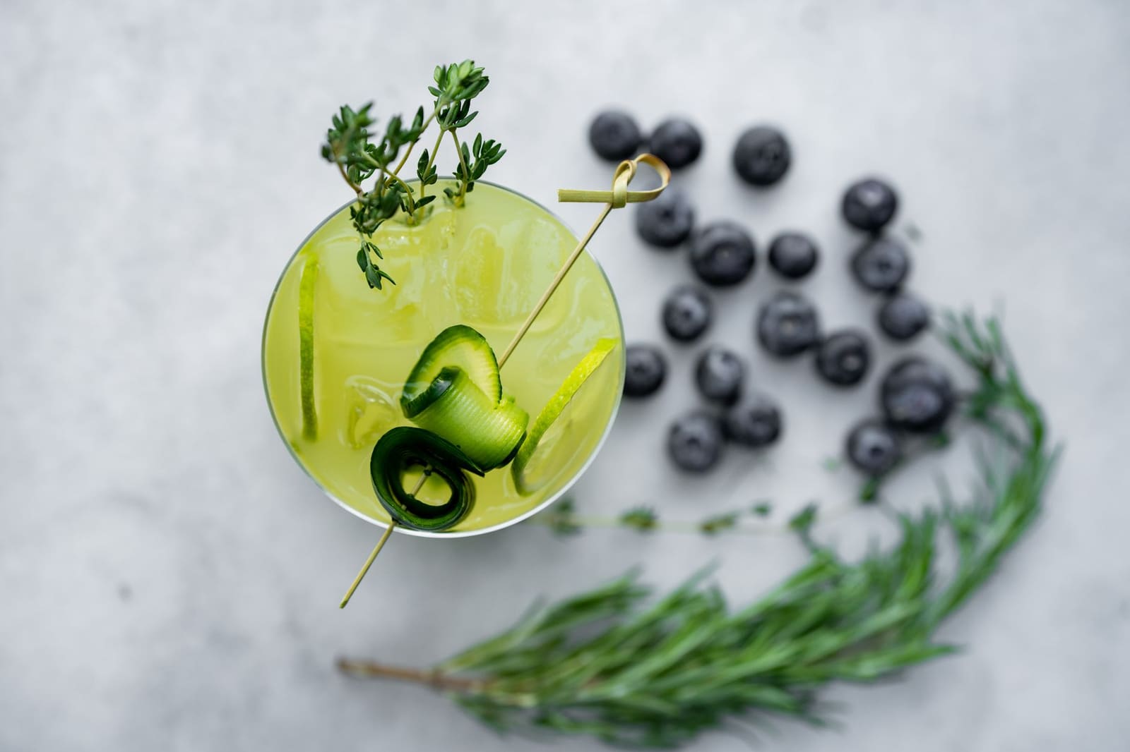 Alcoholvrije Gin Tonic met komkommer en rozemarijn geserveerd in een highballglas met ijs