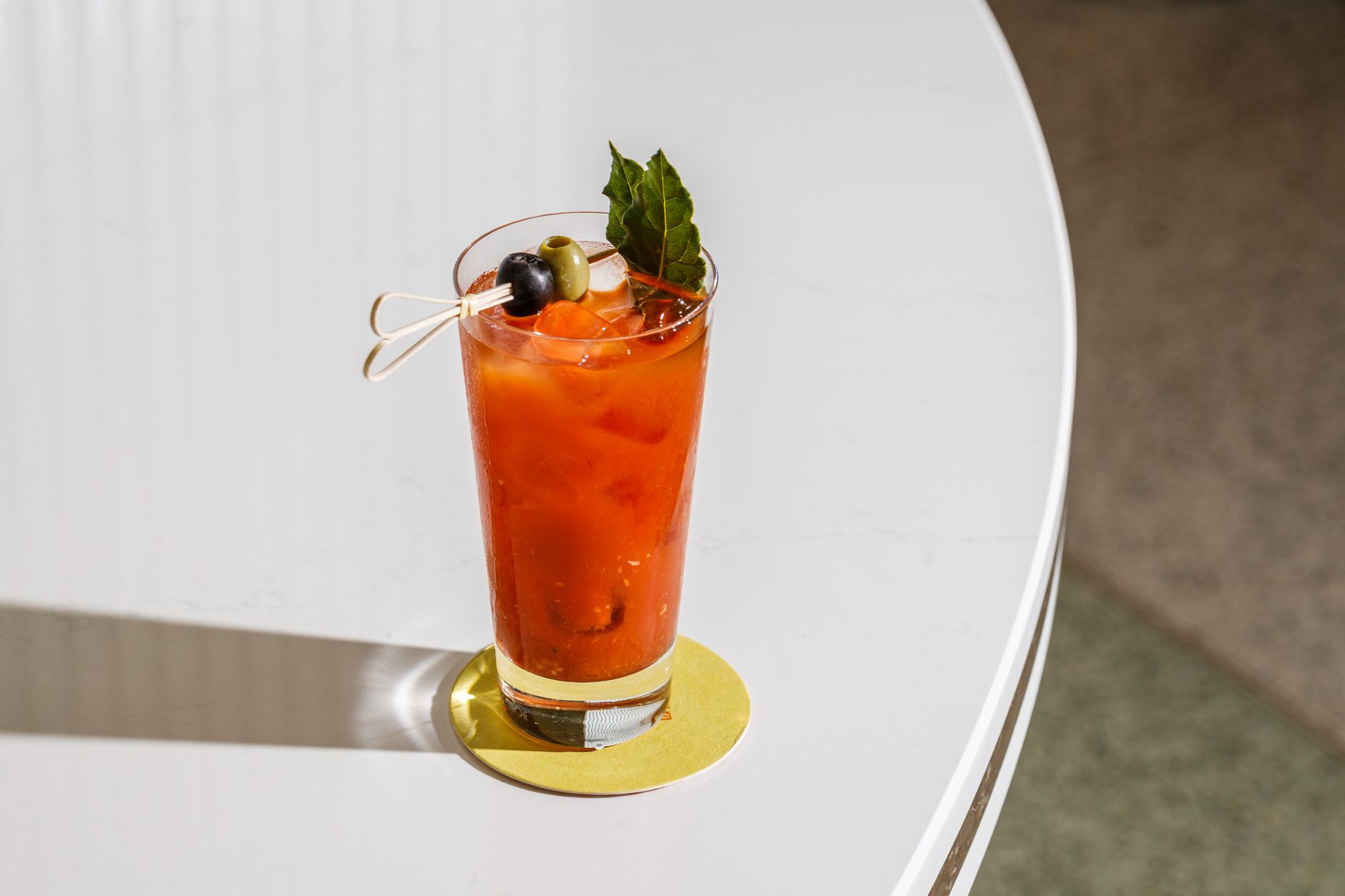Bloody Mary cocktail in een longdrinkglas met bleekselderij en limoen als garnering