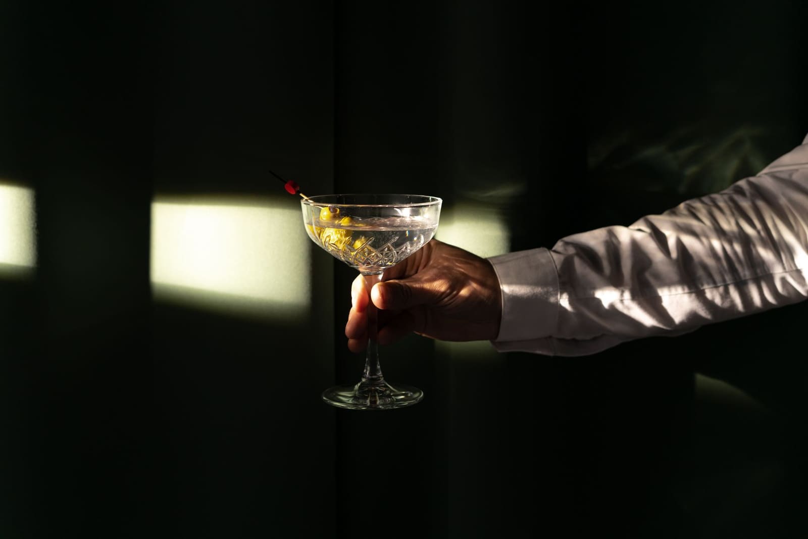 Een Dirty Martini in een gekoeld Martiniglas met twee groene olijven op een prikker
