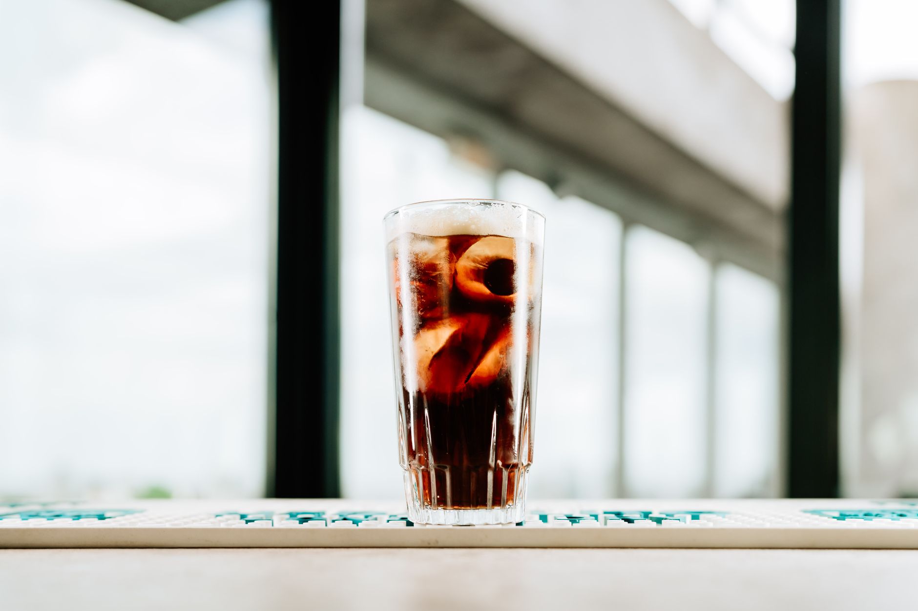 Espresso Tonic in een highballglas met ijs en een laagje espresso bovenop tonic water
