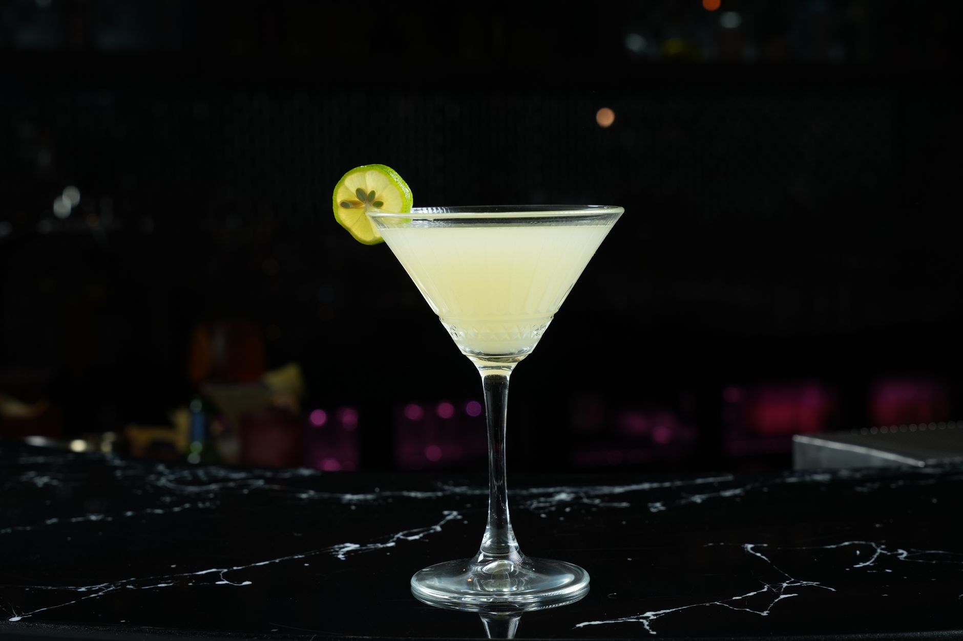 Gimlet cocktail in een coupe glas met een schijfje limoen als garnering