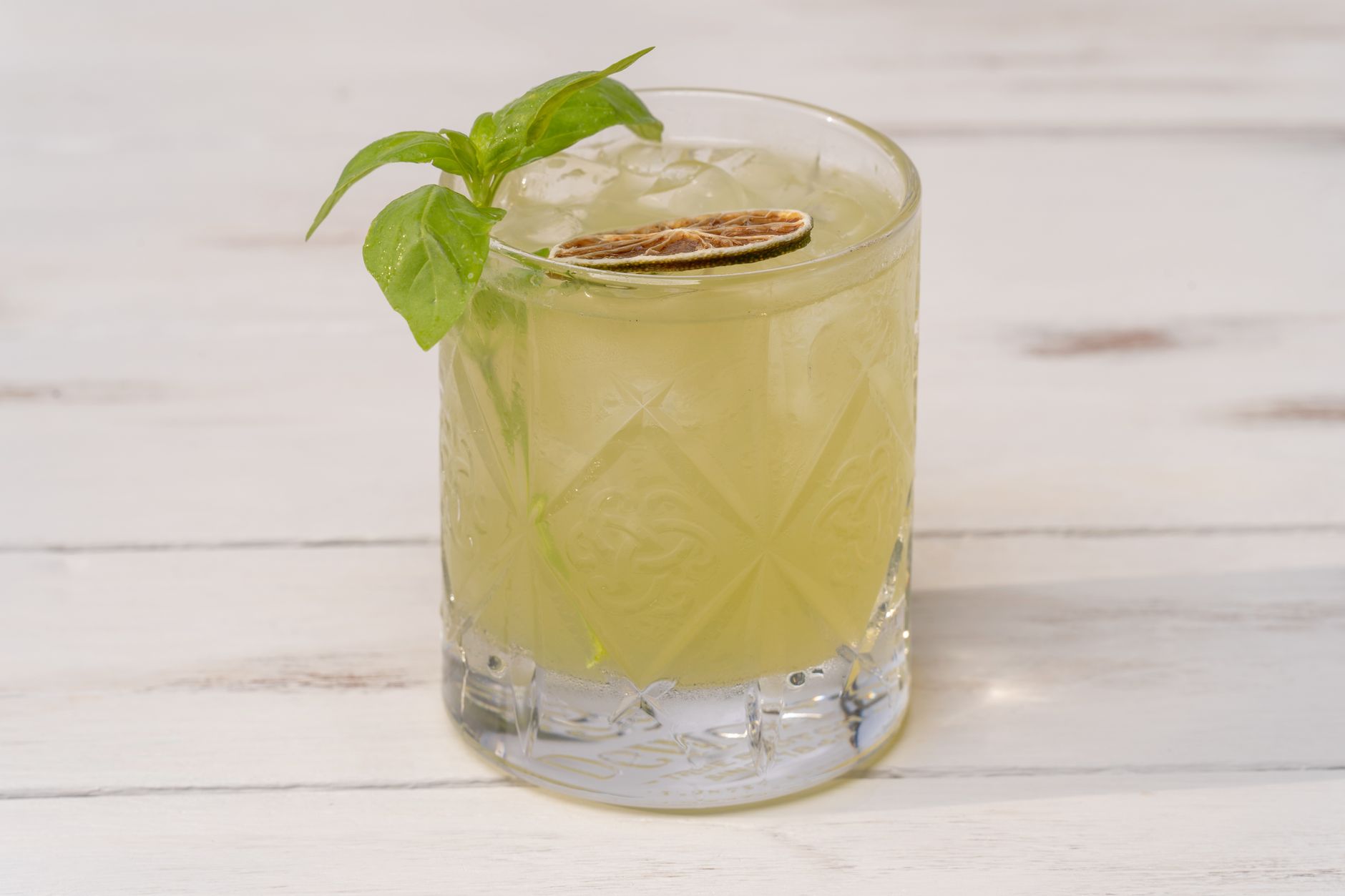 Ginger Basil Smash mocktail in een highball glas met basilicum en limoen garnering