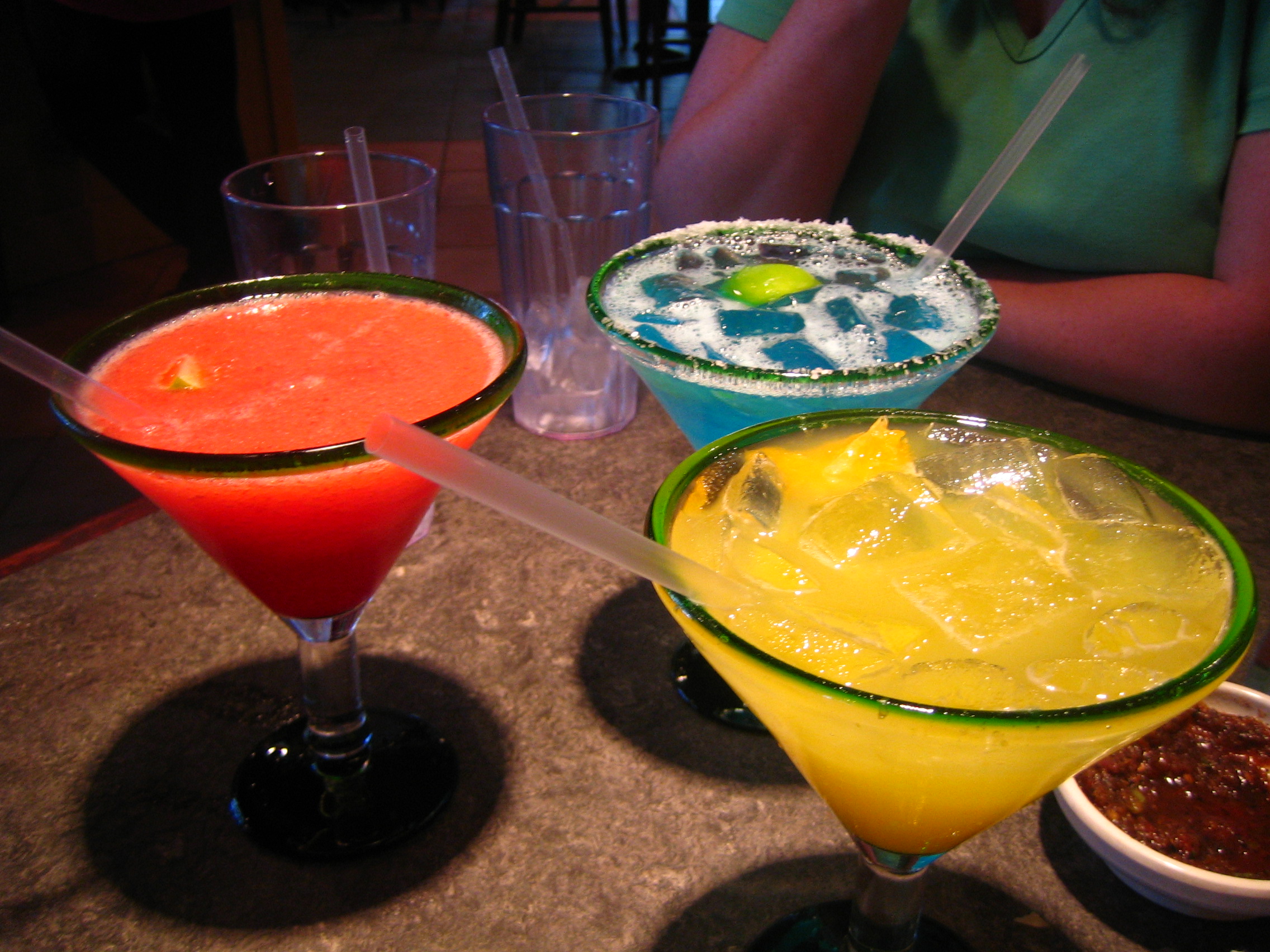 Margarita cocktail met zoutrand en limoenschijfje geserveerd in een coupeglas op een bar