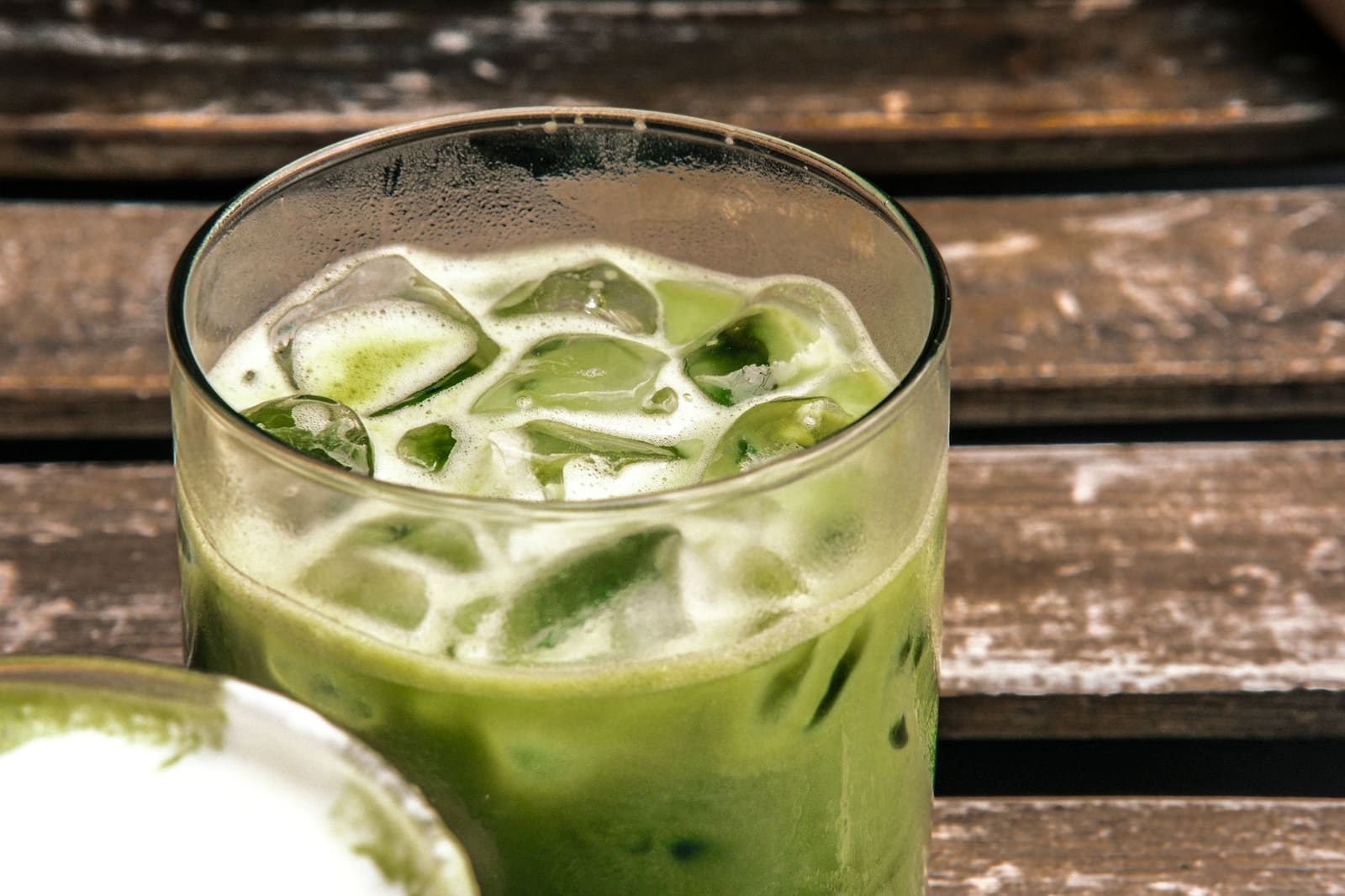 Een groene Matcha Tonic in een highball glas met ijs, limoenschijfje en opborrelende tonic