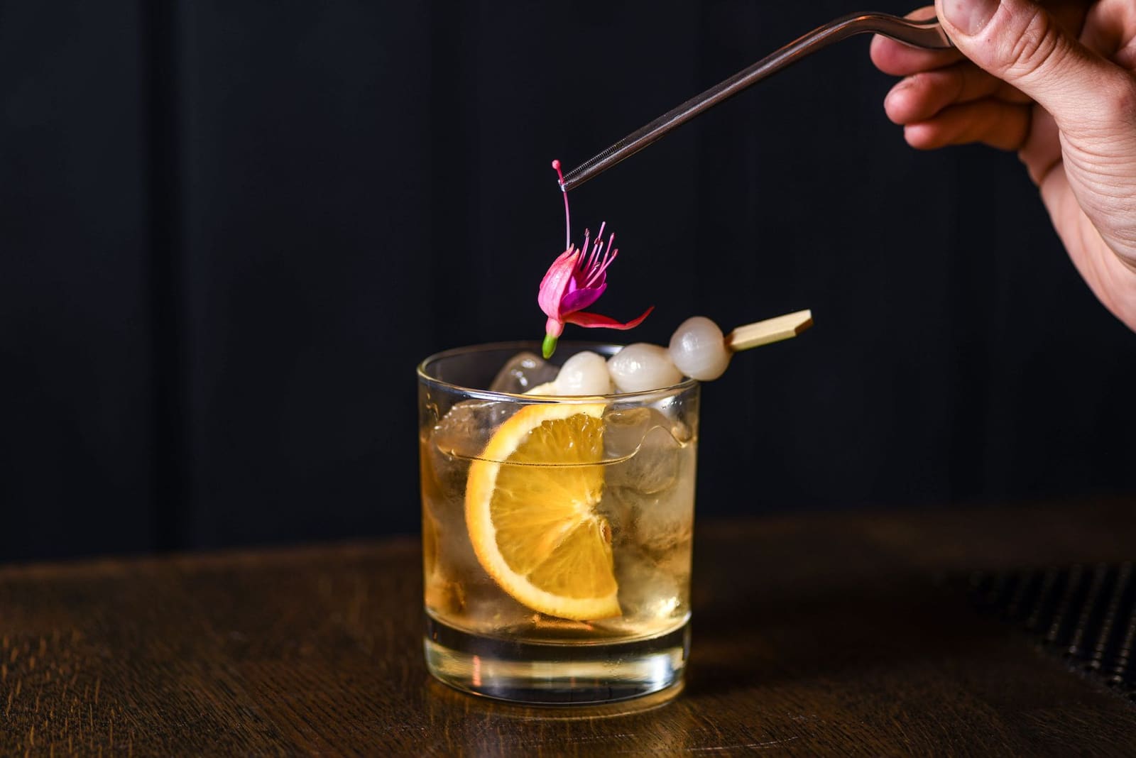 Nogroni cocktail met sinaasappelschil in een rocksglas op ijs
